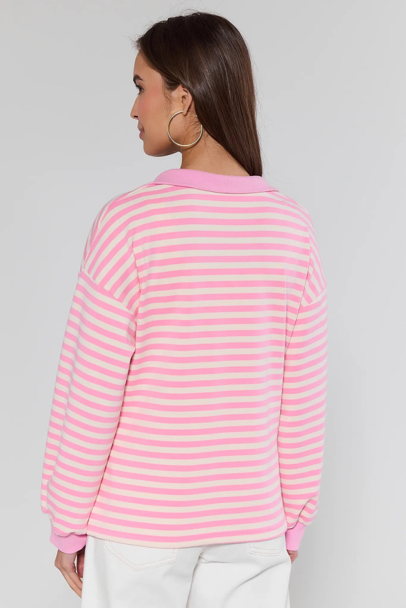 model wearing pink top with white stripes on white background