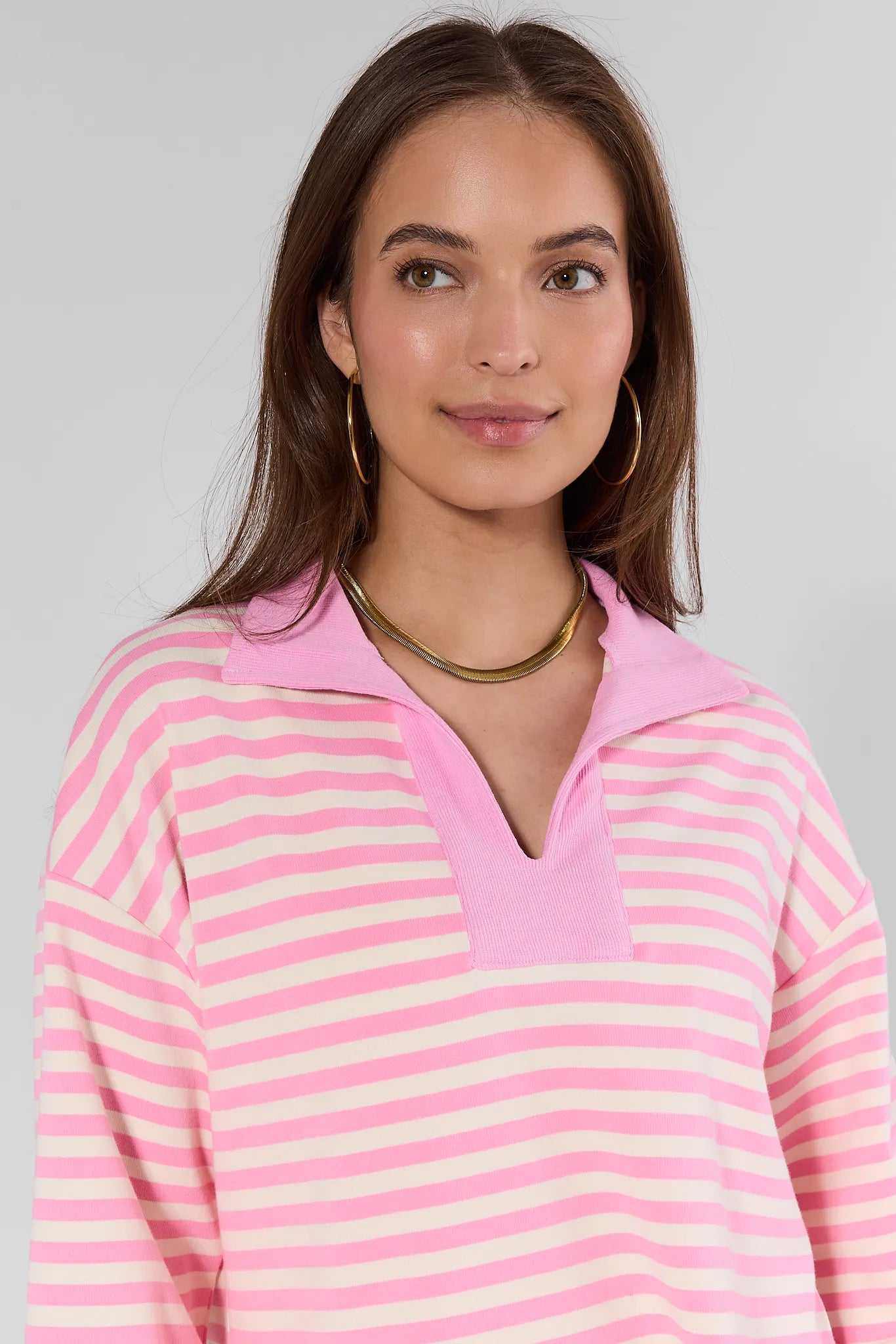model wearing pink top with stripes on white background
