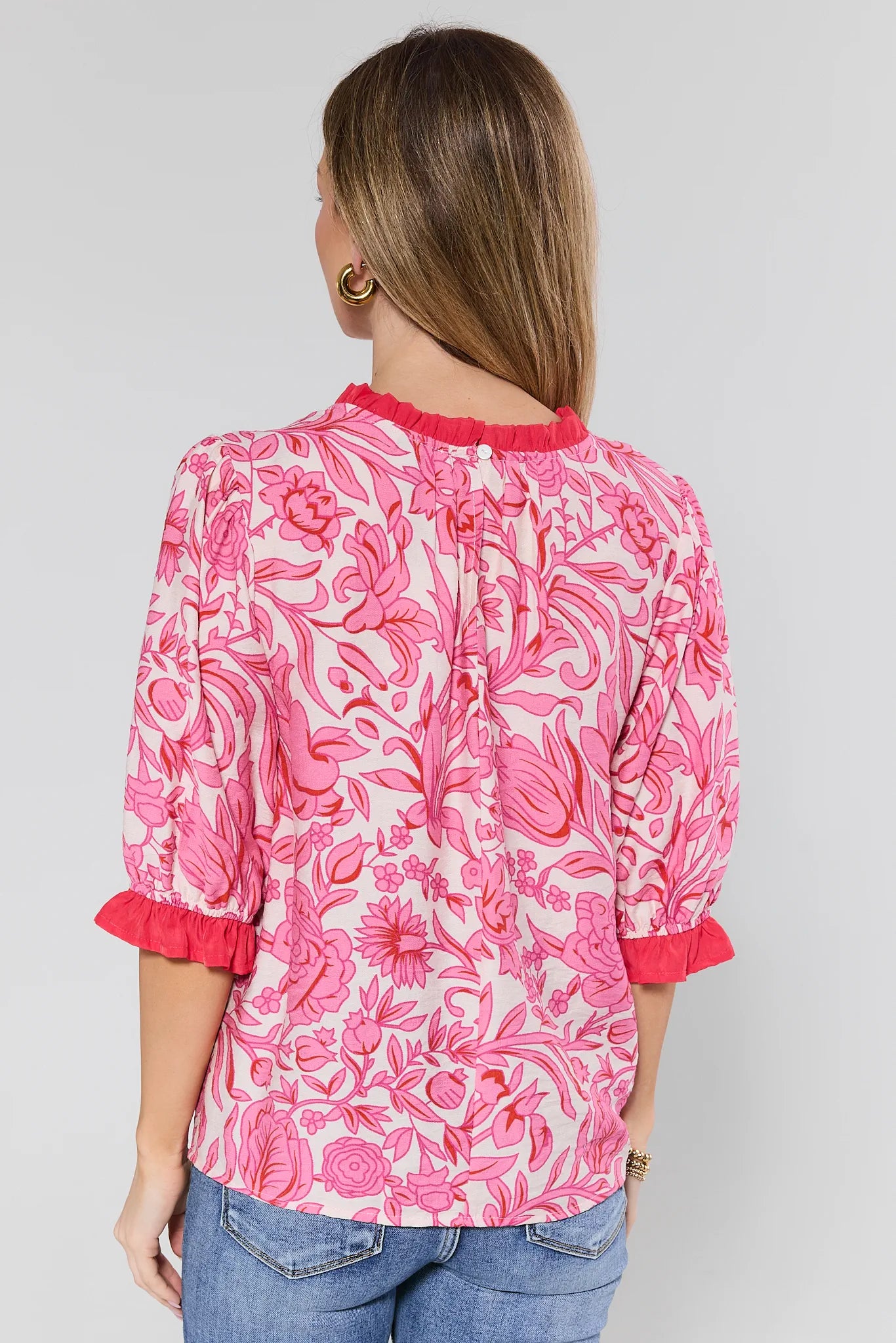 woman wearing a pink floral puff sleeve top on a white background