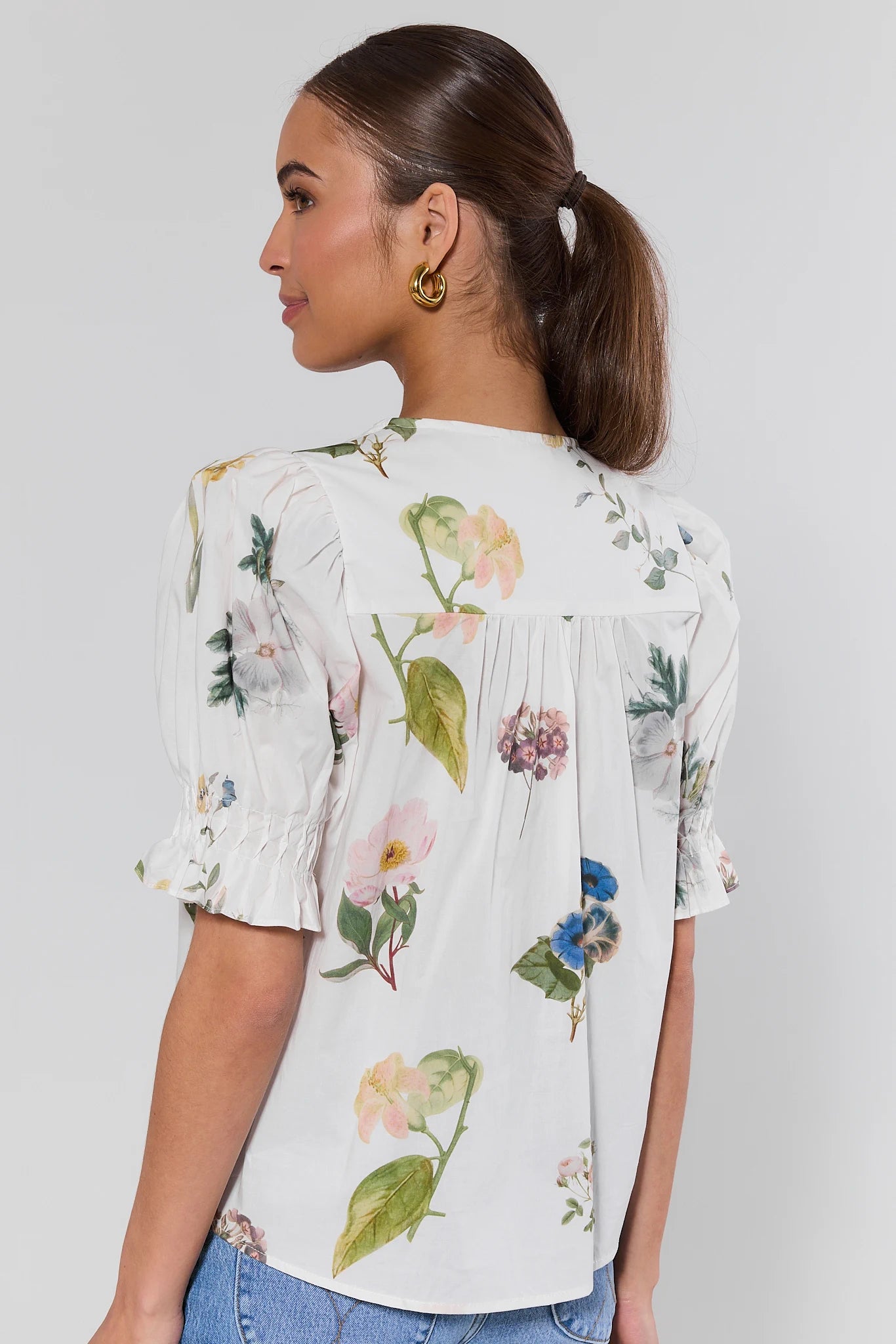 Woman wearing a floral blouse with a plain background