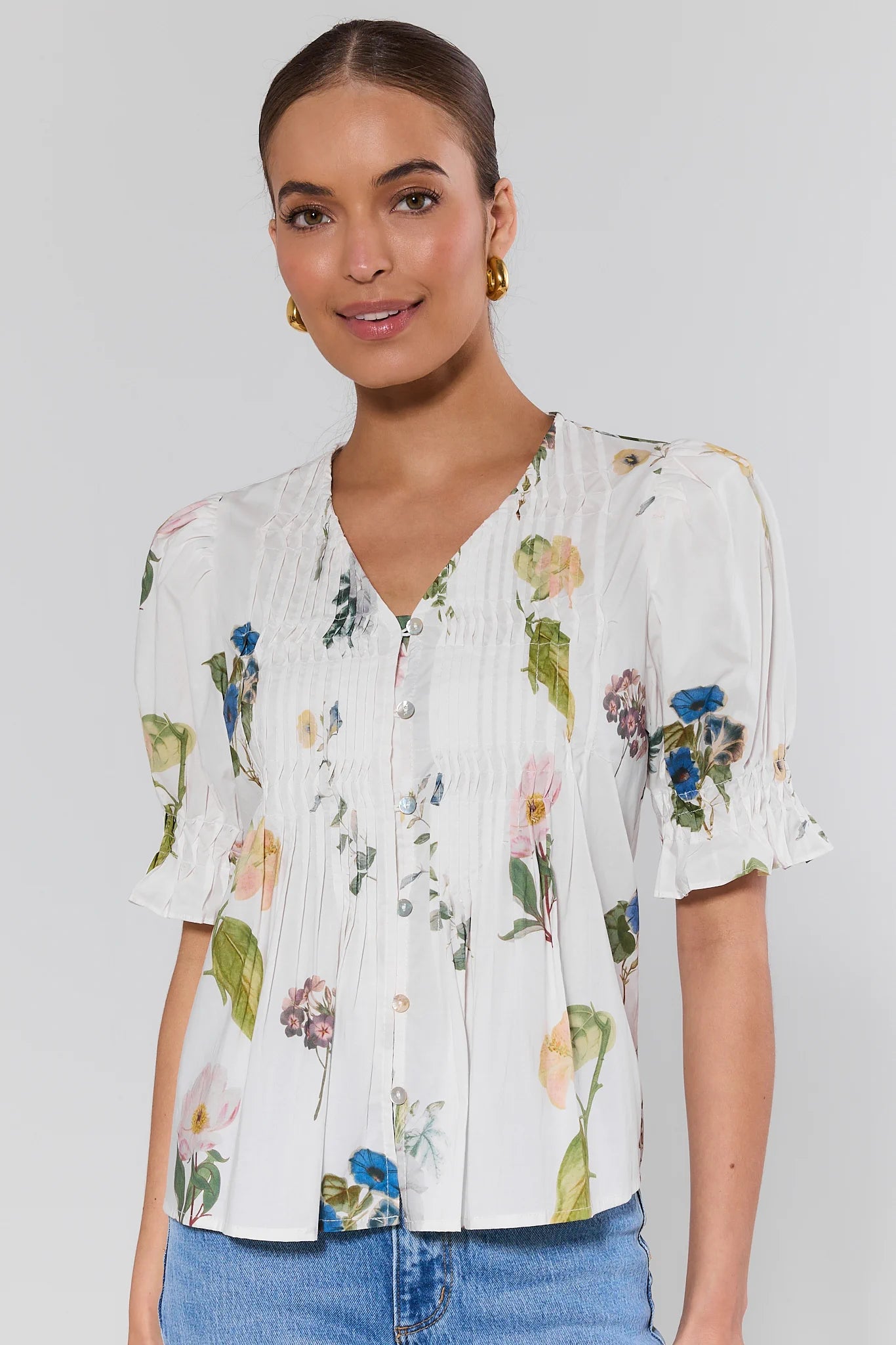 Woman wearing a floral blouse with a plain background