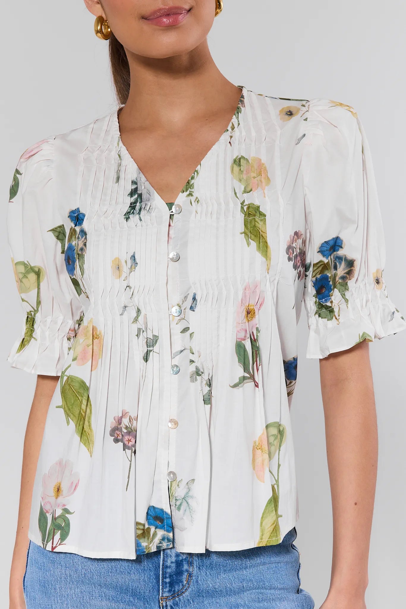 Woman wearing a floral blouse with a plain background