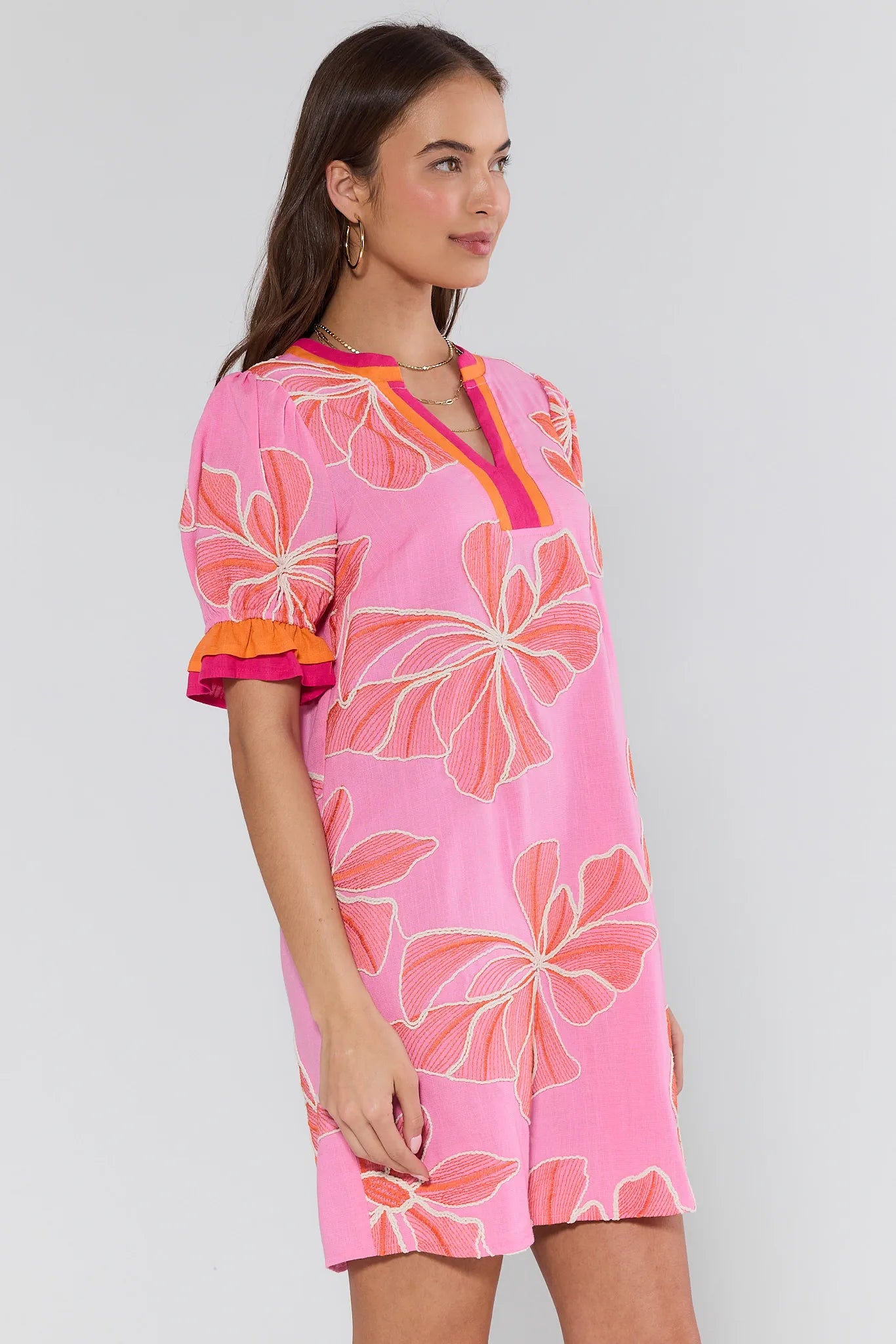 Woman wearing a pink floral dress against a white background