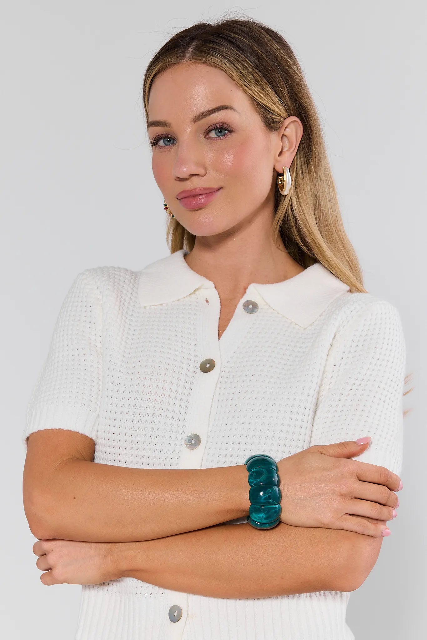 Woman wearing a white textured shirt with a plain background