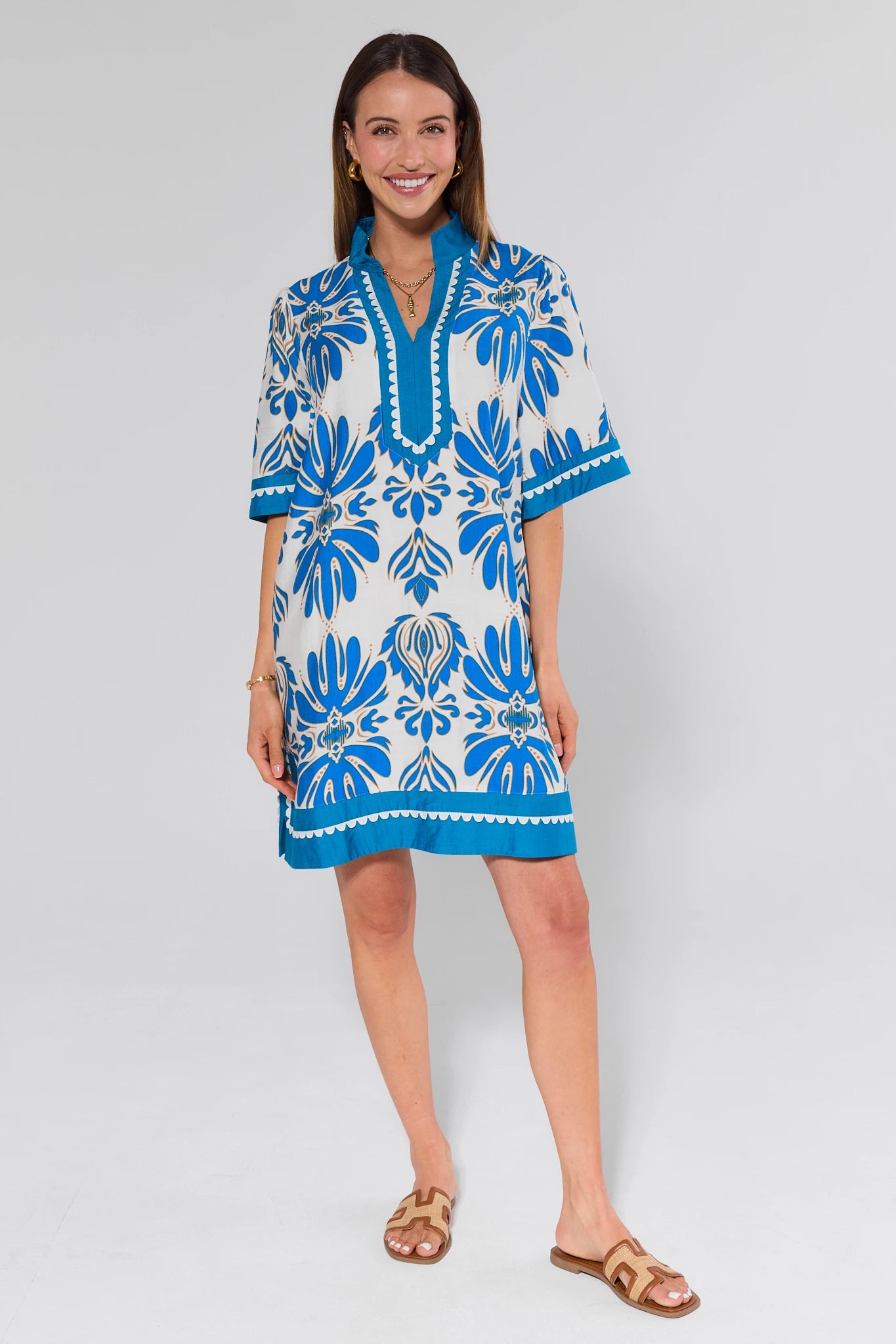 Woman wearing a blue and white patterned dress on a light gray background