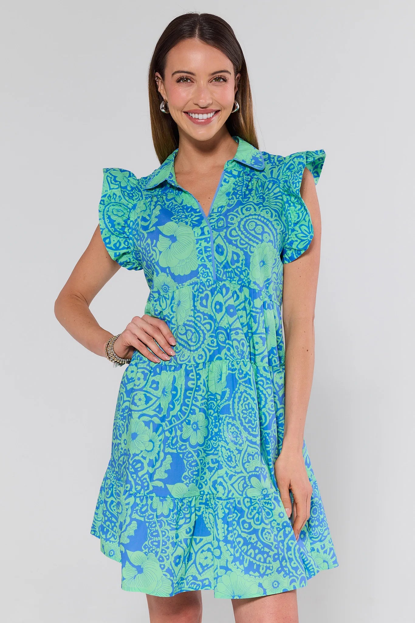 Woman wearing a blue and green patterned dress on a white background