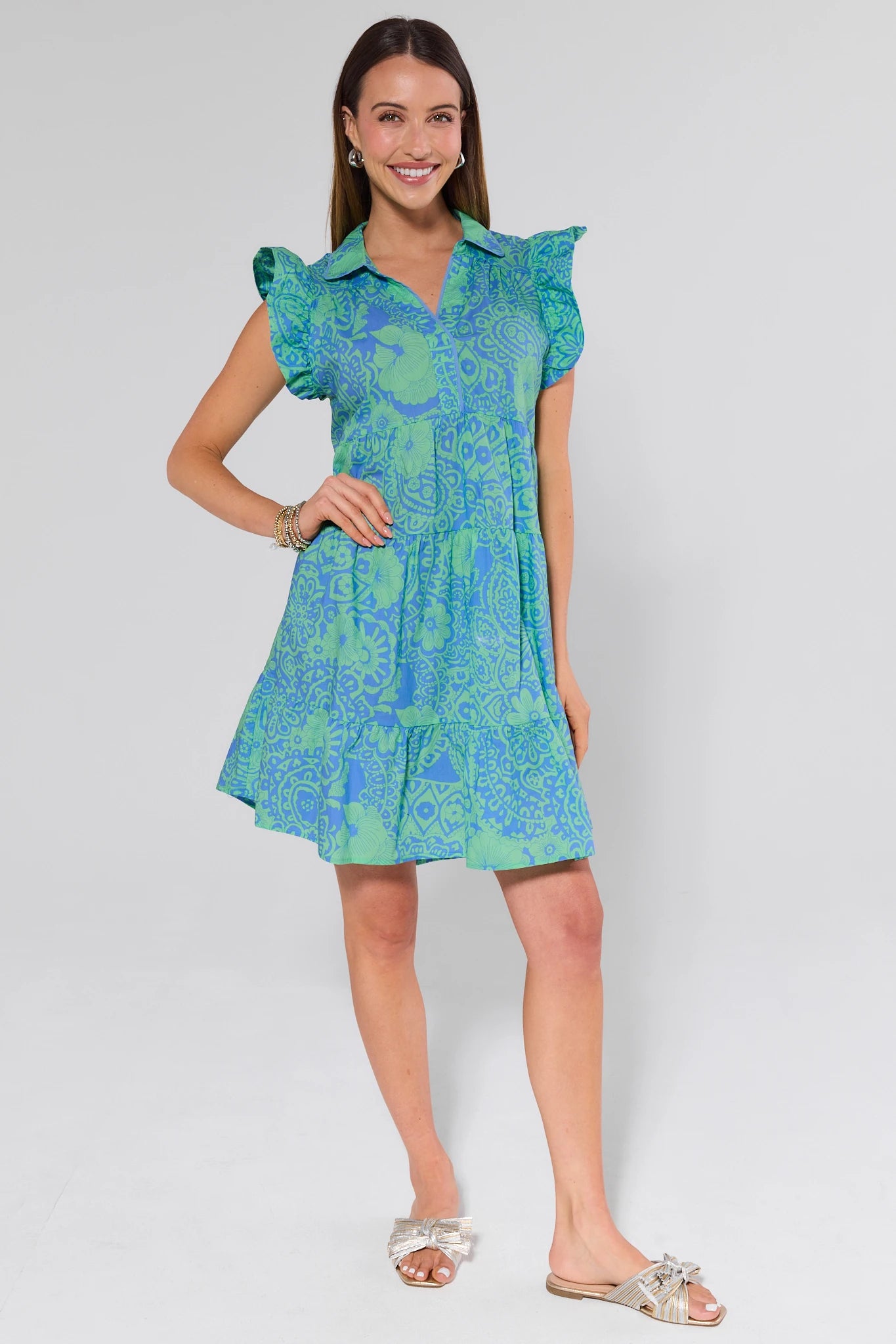 Woman wearing a green patterned dress on a white background