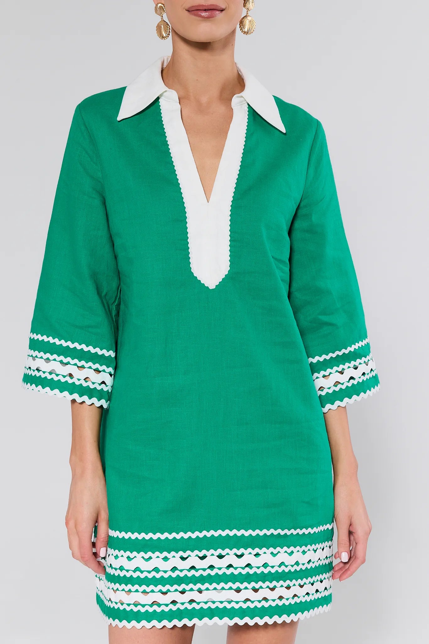 Green dress with white trim on a plain background