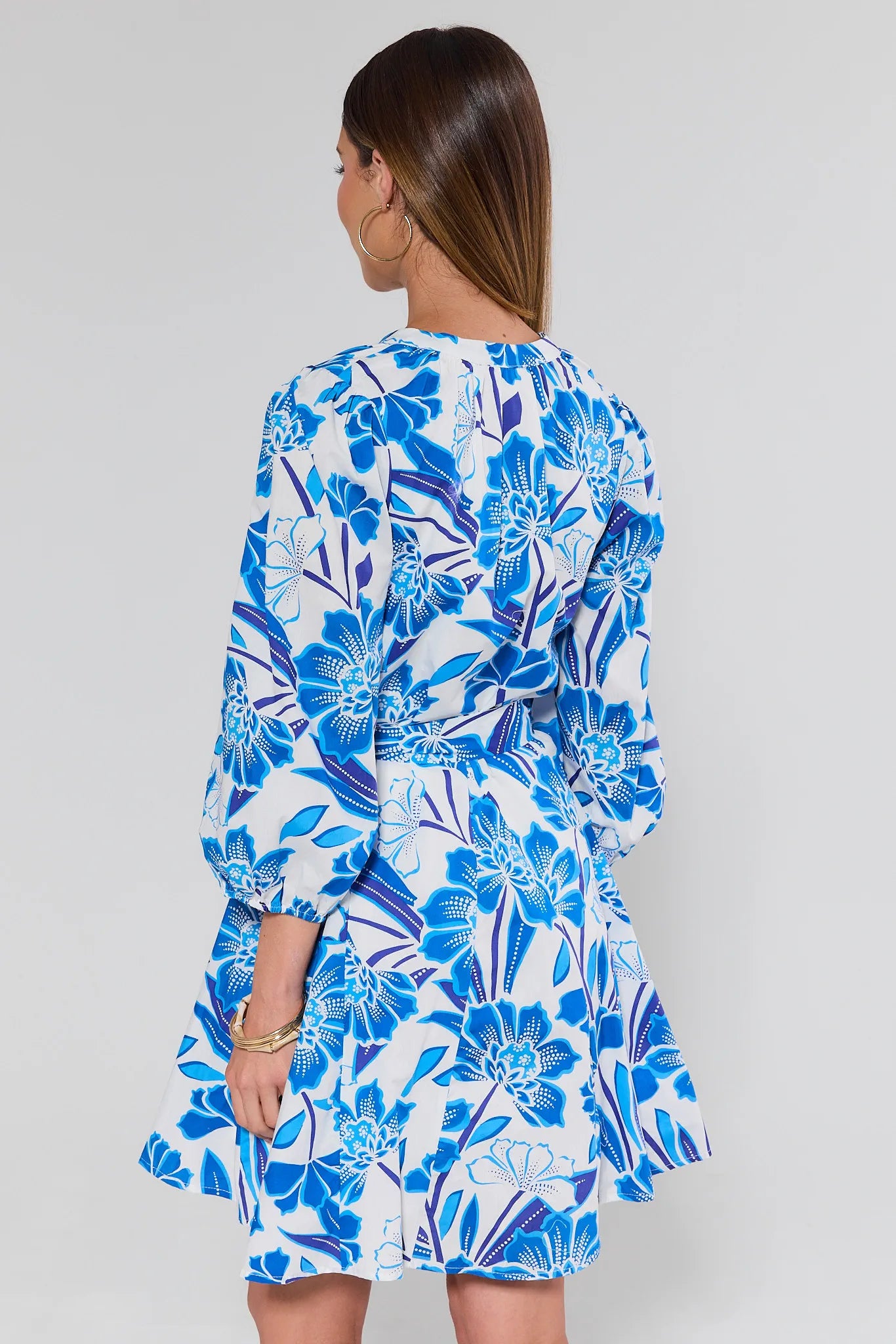 wearing a blue floral dress against a plain background