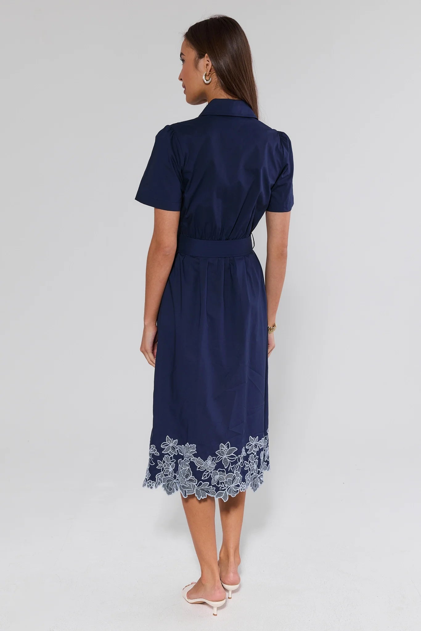 Navy dress with lace details on a white background