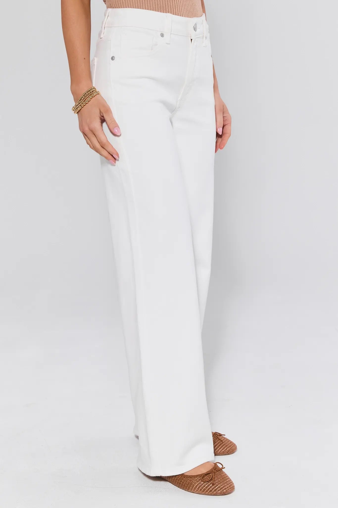 White pants worn by a person on a plain background