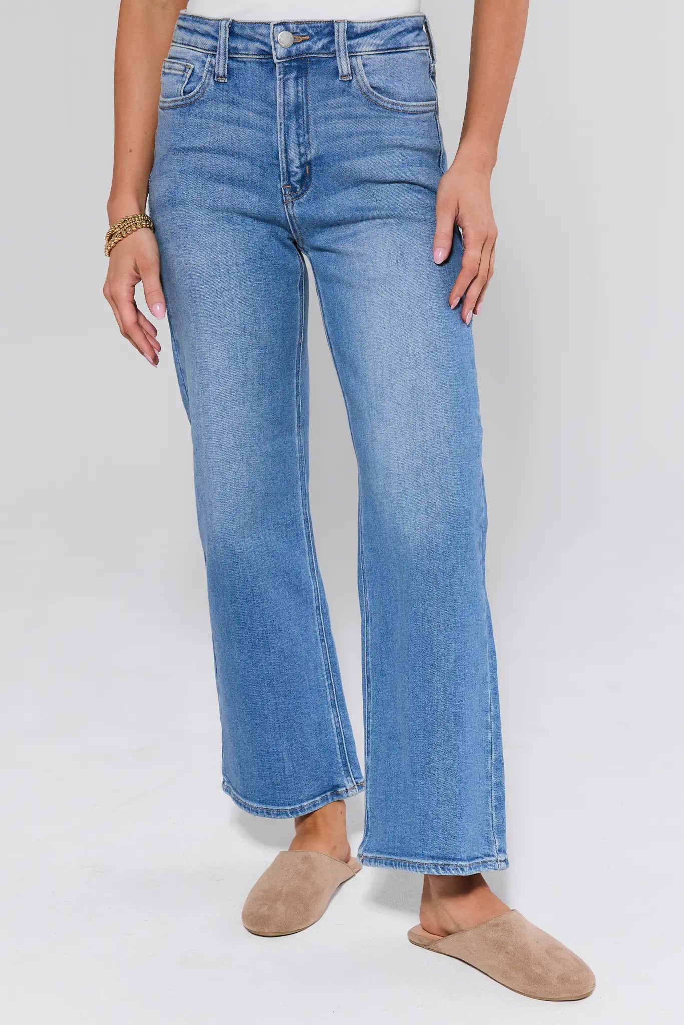 Person wearing light blue jeans on a white background
