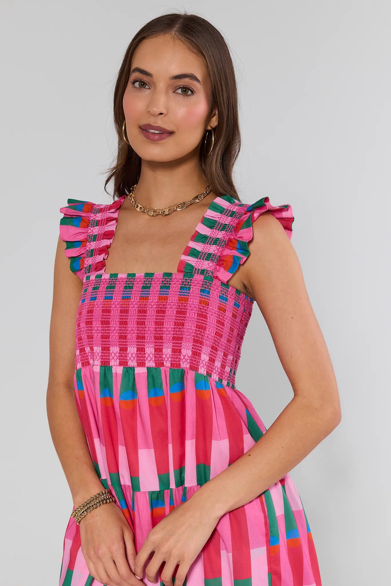 Woman wearing a colorful dress with a plain background
