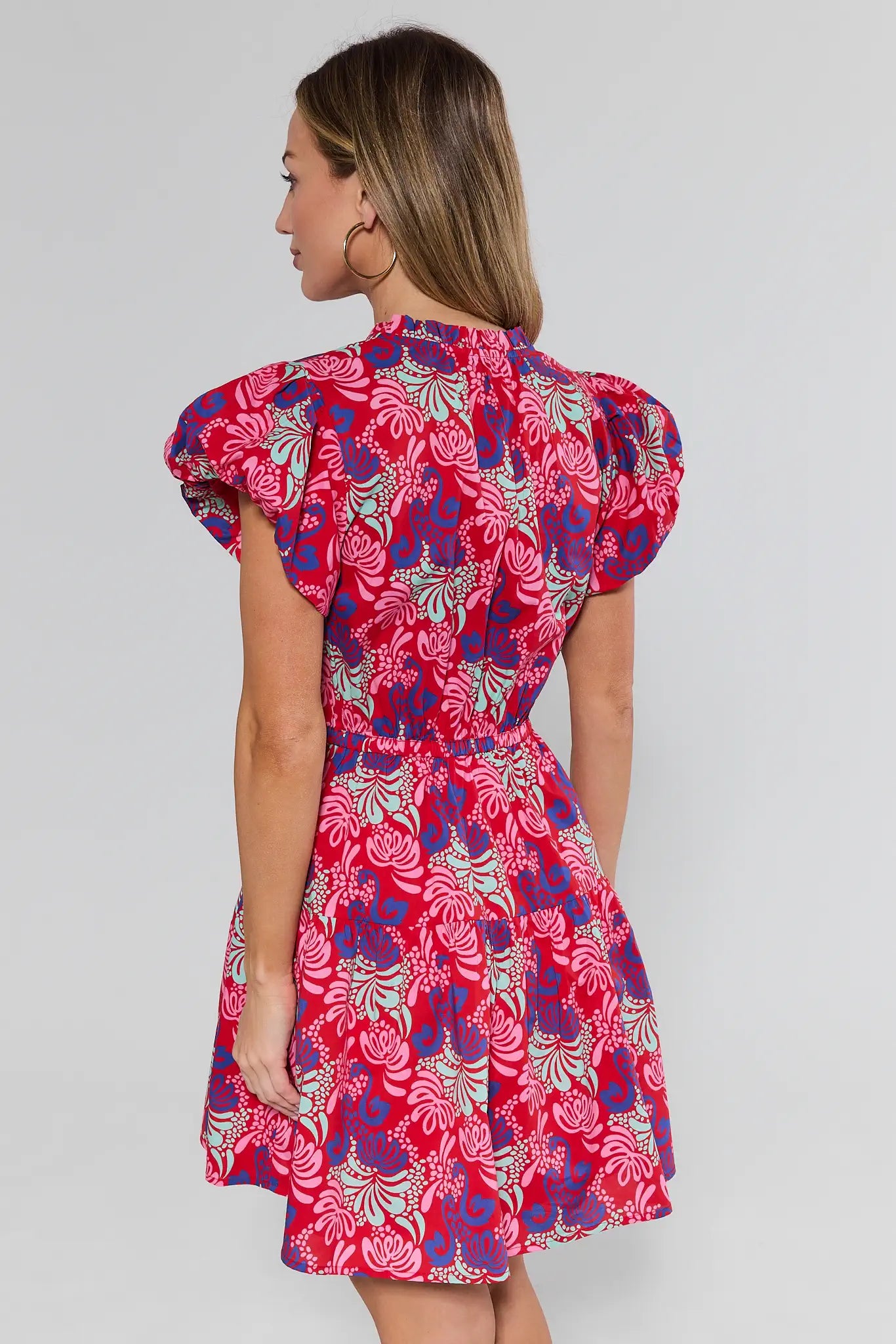 Woman wearing a red floral dress on a white background