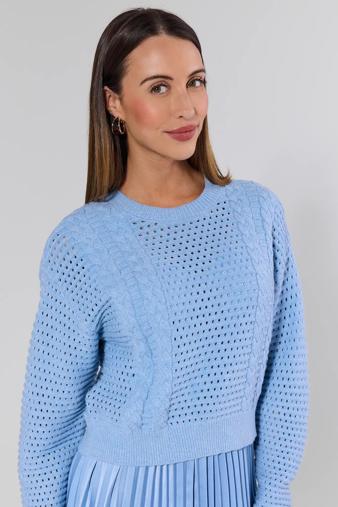 Woman wearing a light blue sweater against a plain background