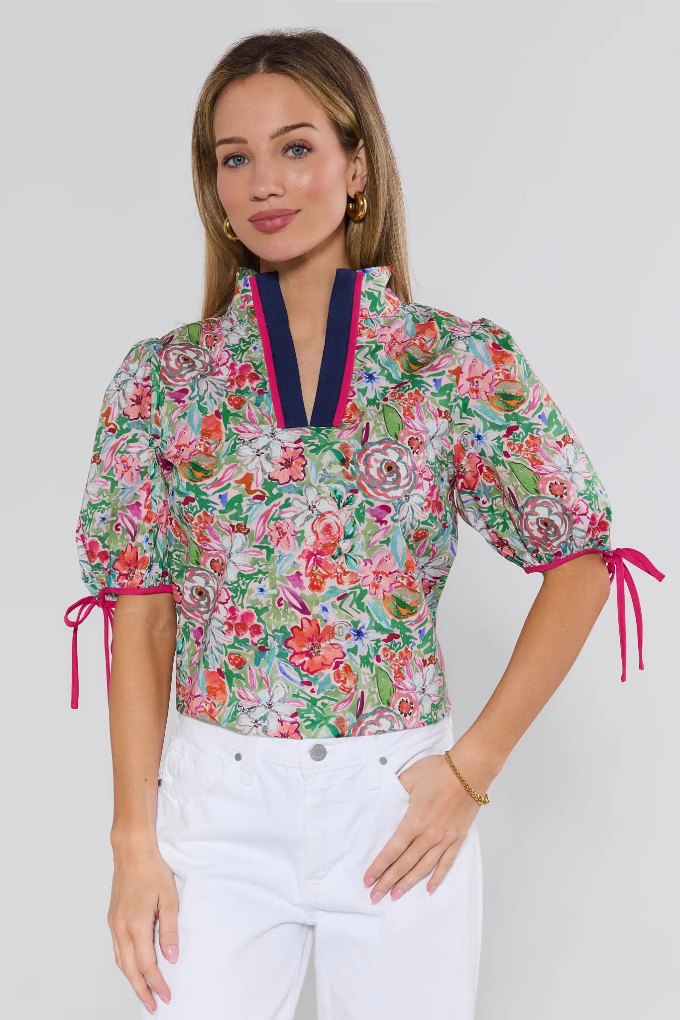Woman wearing a colorful floral blouse with puff sleeves on a white background