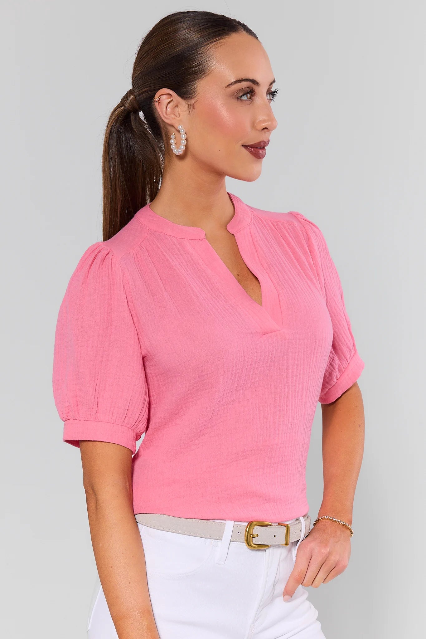 Woman wearing a pink blouse with a gray background