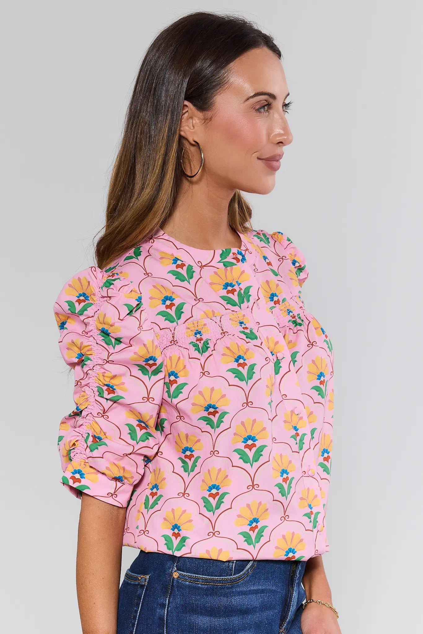 Woman wearing a pink floral blouse against a plain background