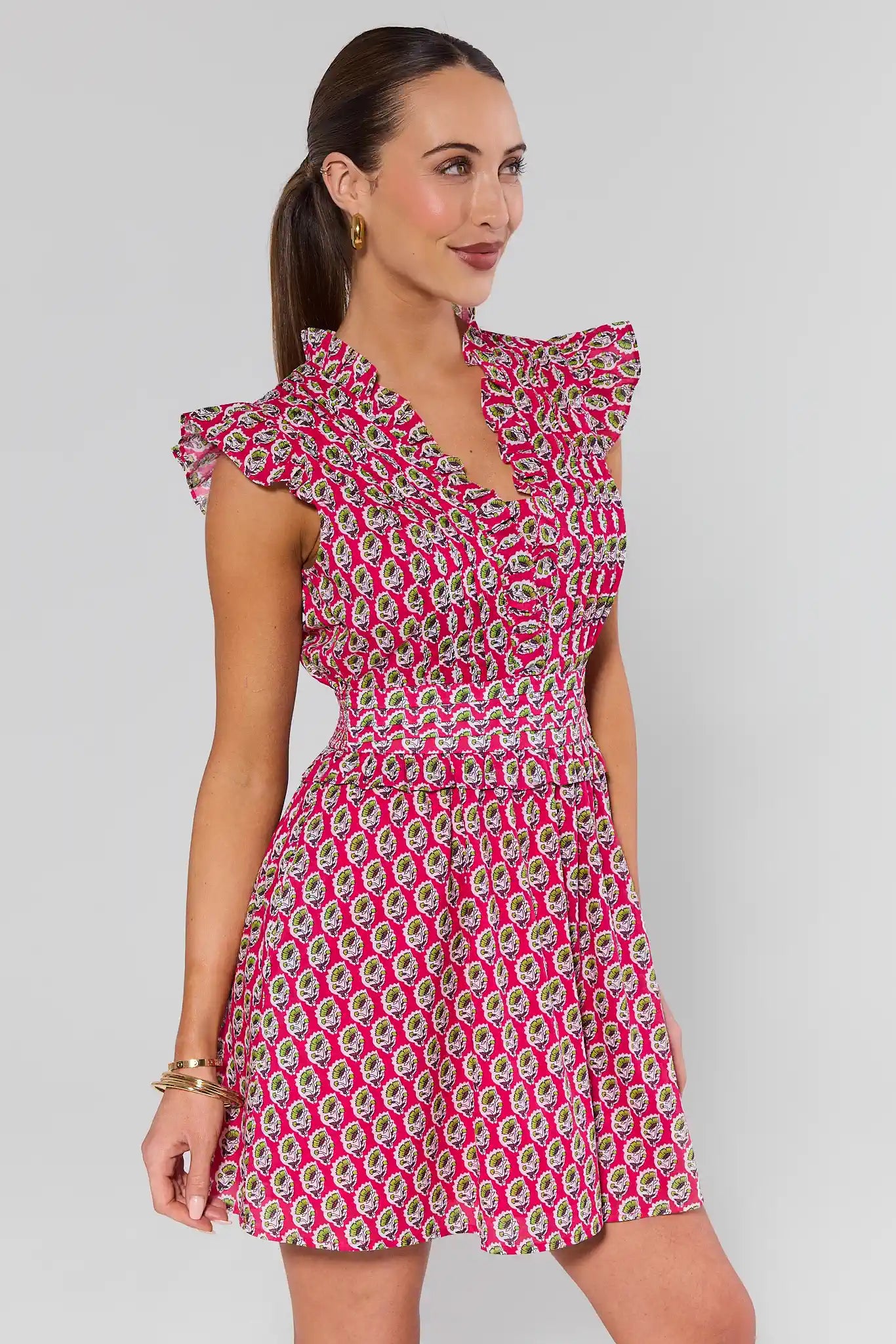 Woman wearing a pink floral dress against a gray background