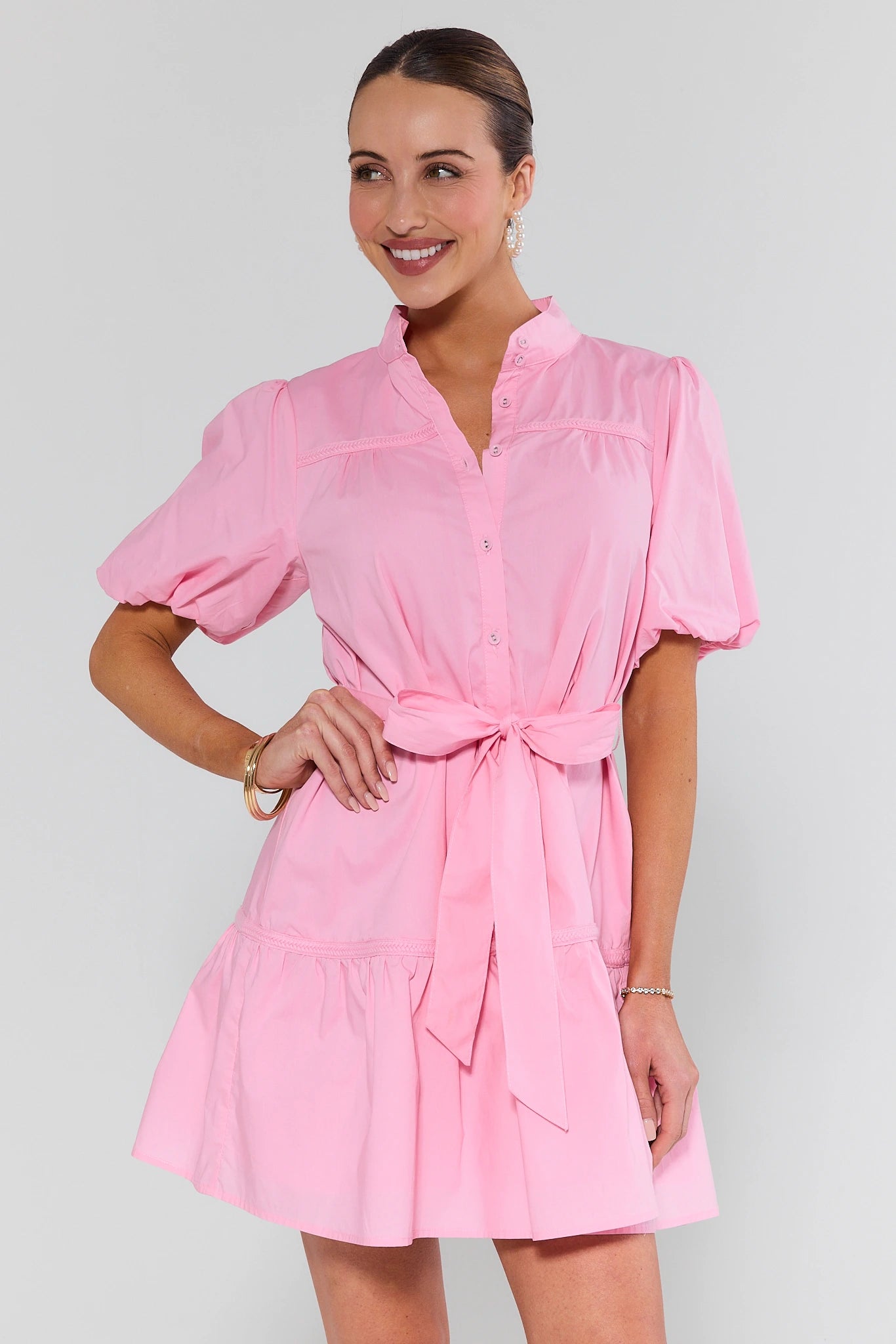 Woman wearing a pink dress with a white background