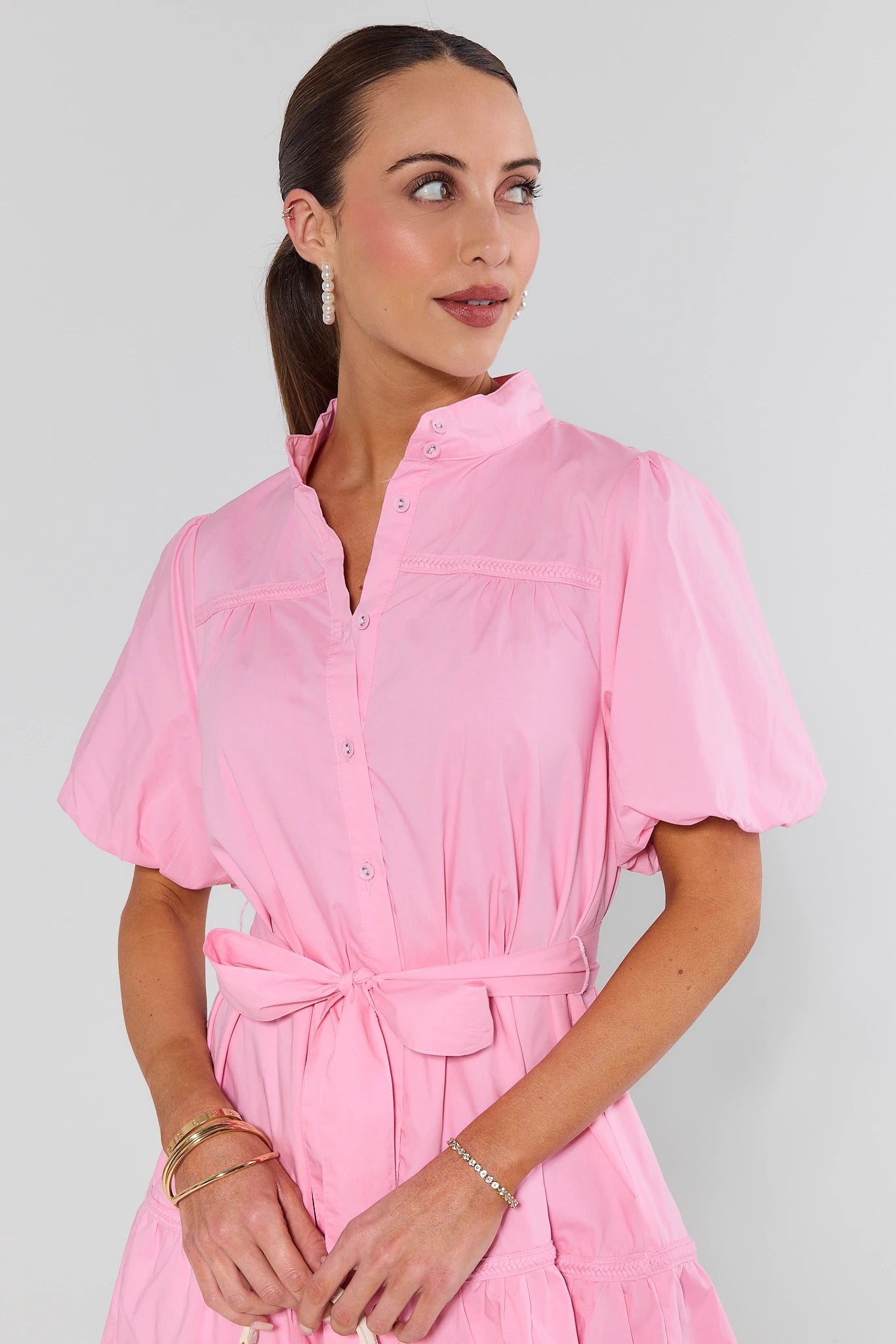 Woman wearing a pink dress against a plain background