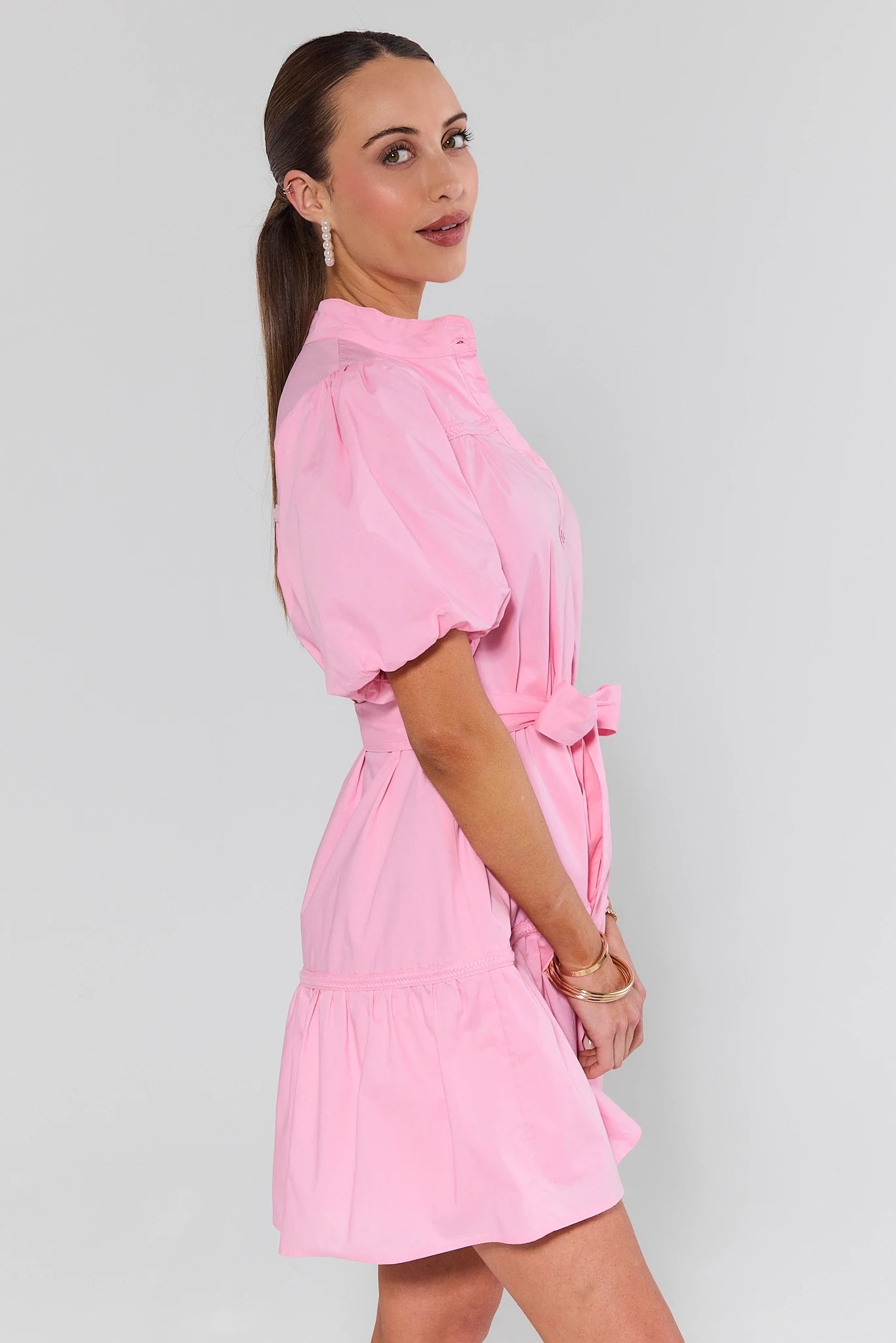 Woman wearing a pink dress against a plain background