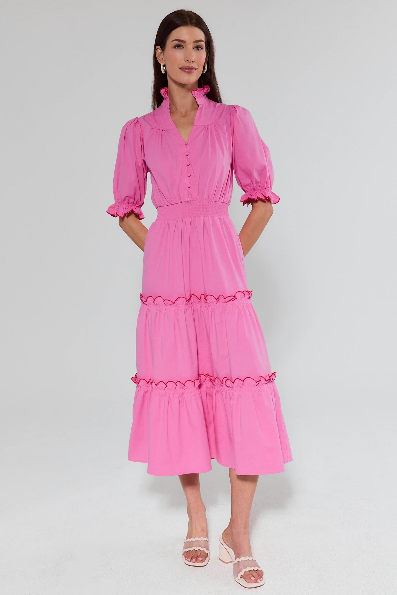 Woman wearing a pink dress with puffed sleeves on a white background