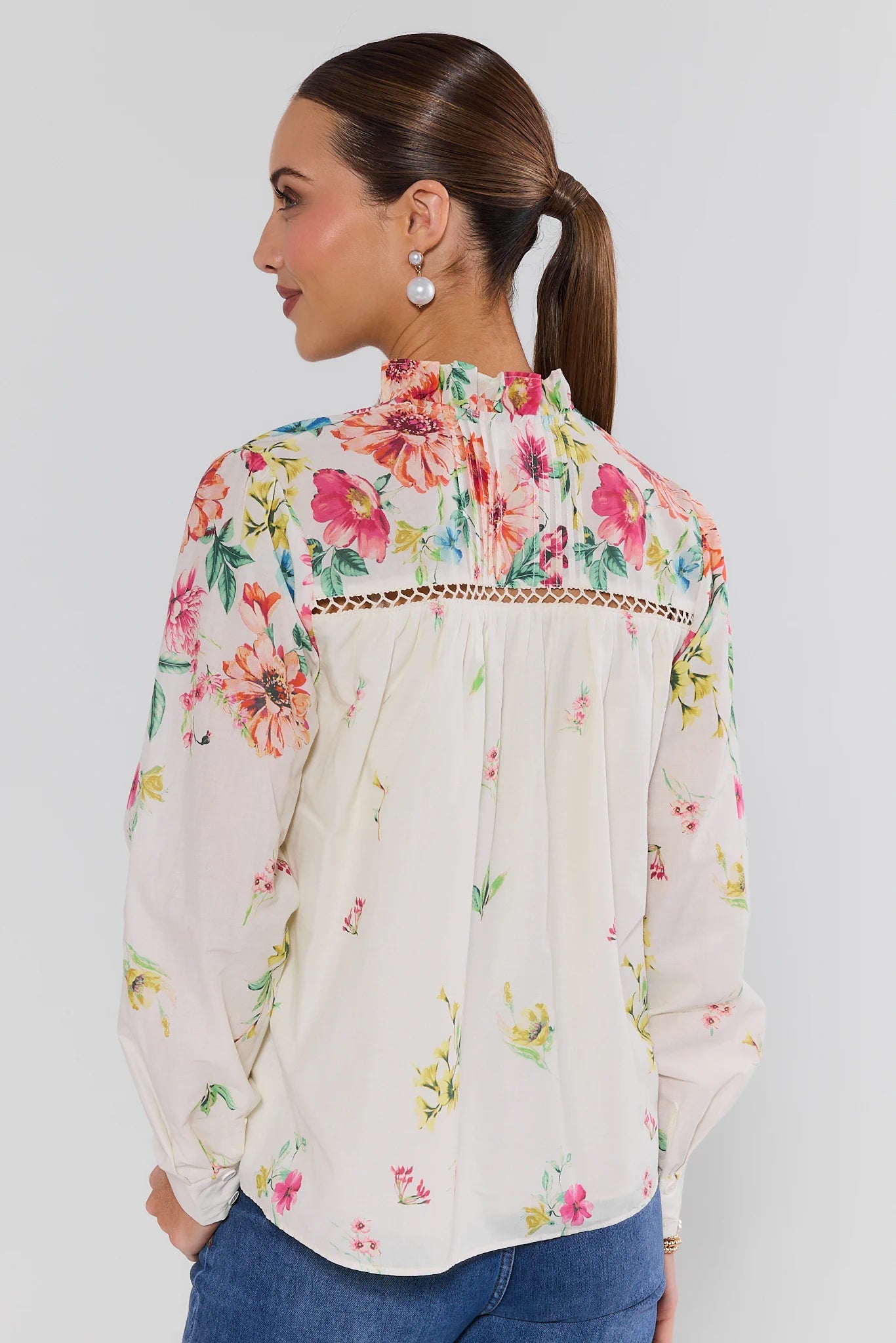 Woman wearing a floral blouse with a plain background