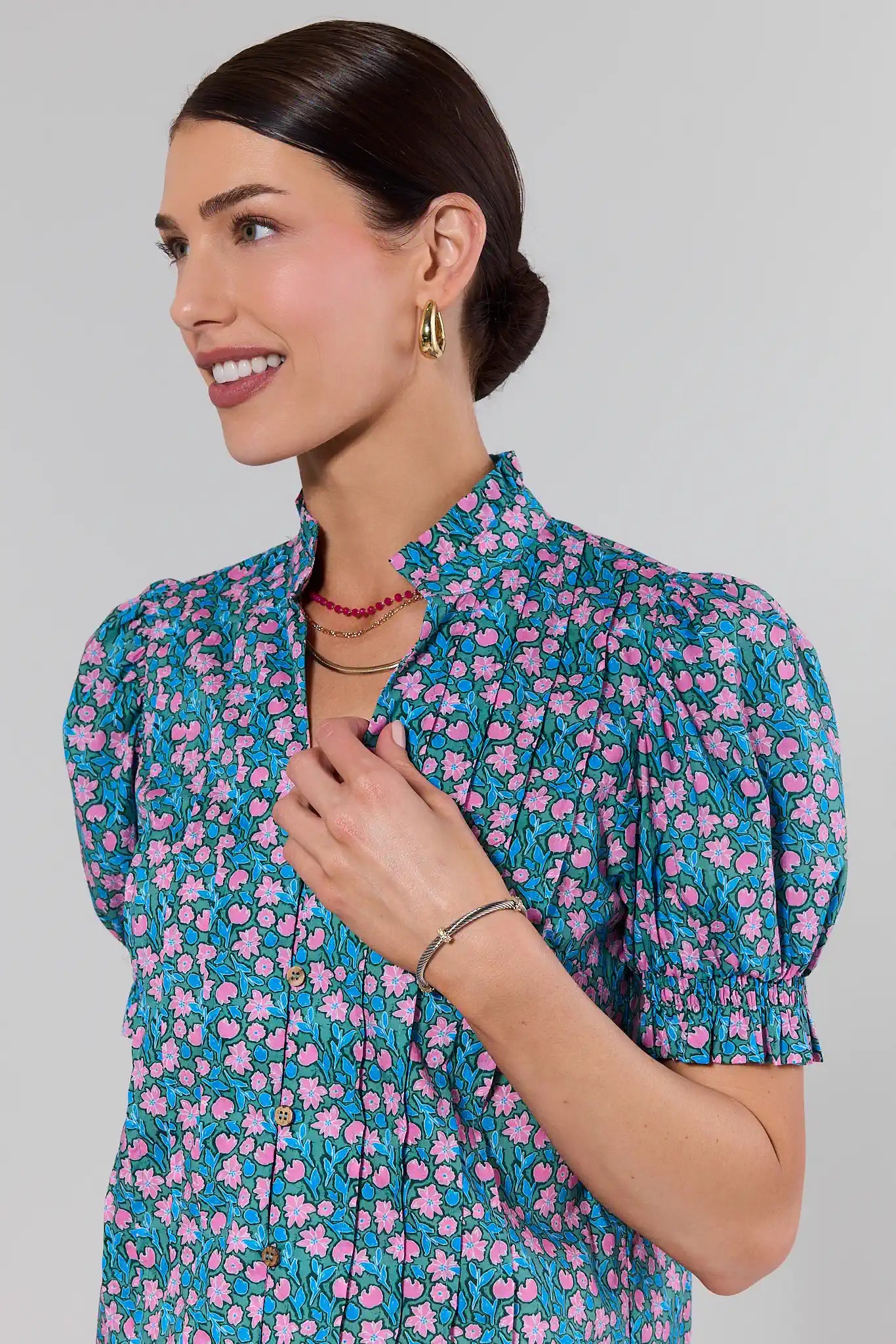 Woman wearing a floral blouse against a plain background