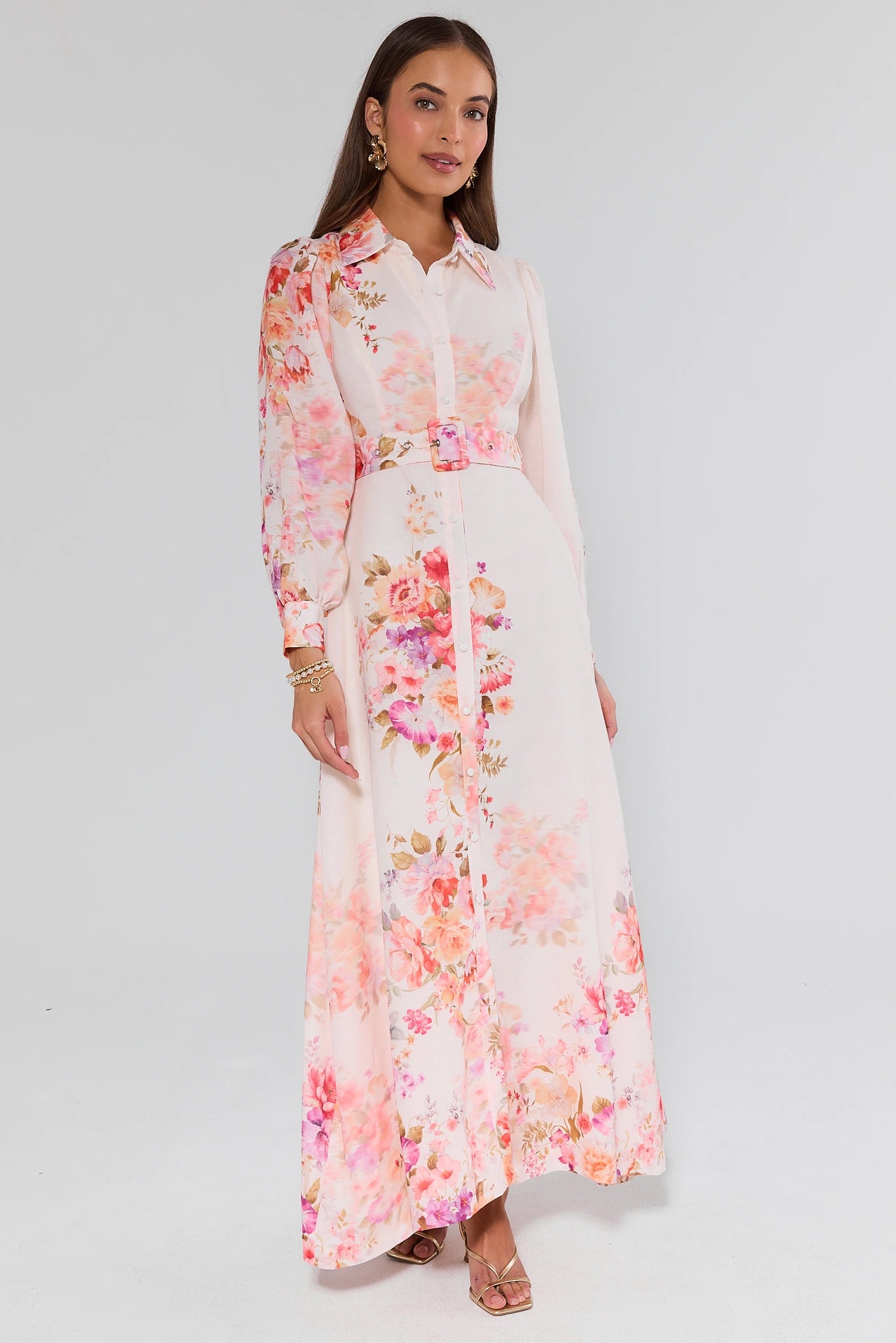 Woman wearing a long floral dress on a white background