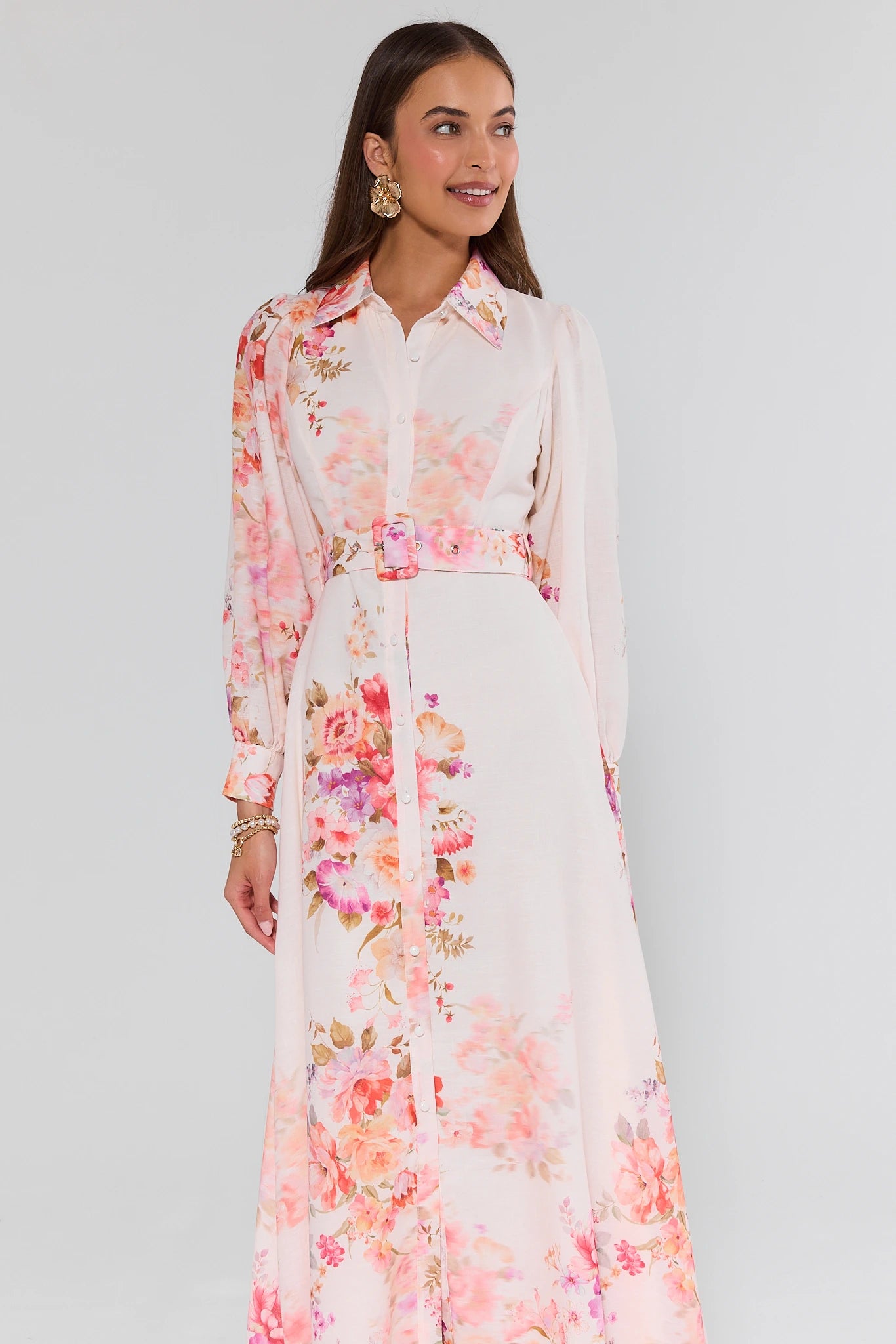 Woman wearing a long floral dress with a white background