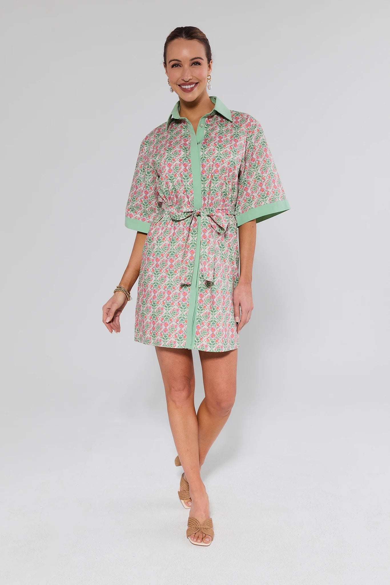 Woman wearing a patterned dress on a plain background