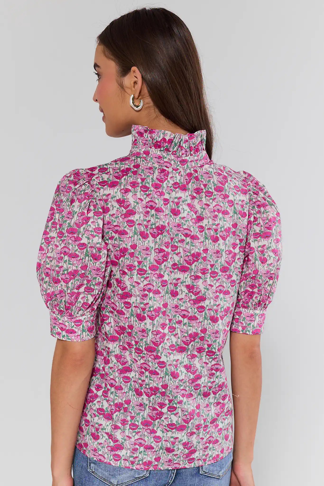 Woman wearing a floral blouse with a plain background