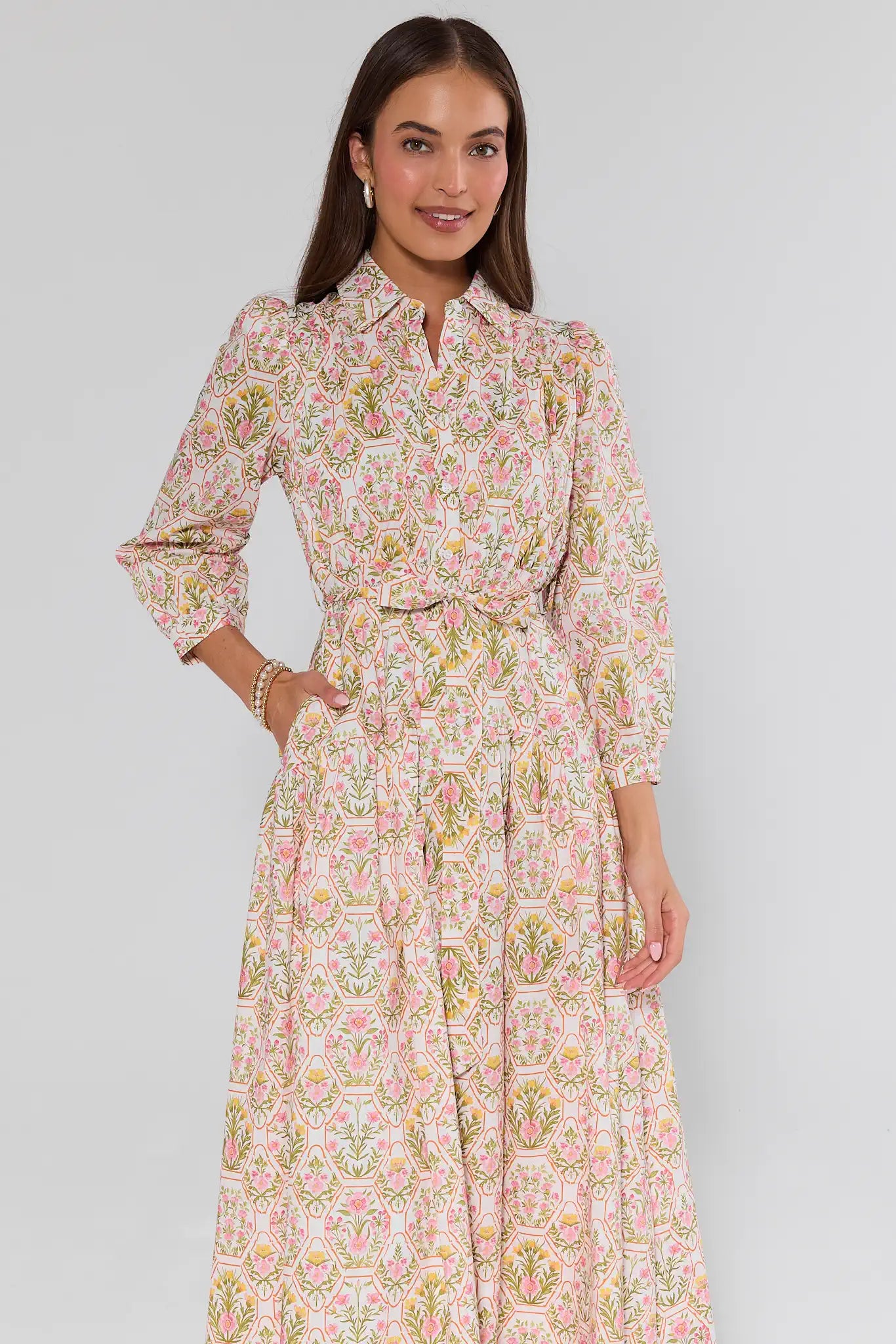 Woman wearing a floral dress against a plain background