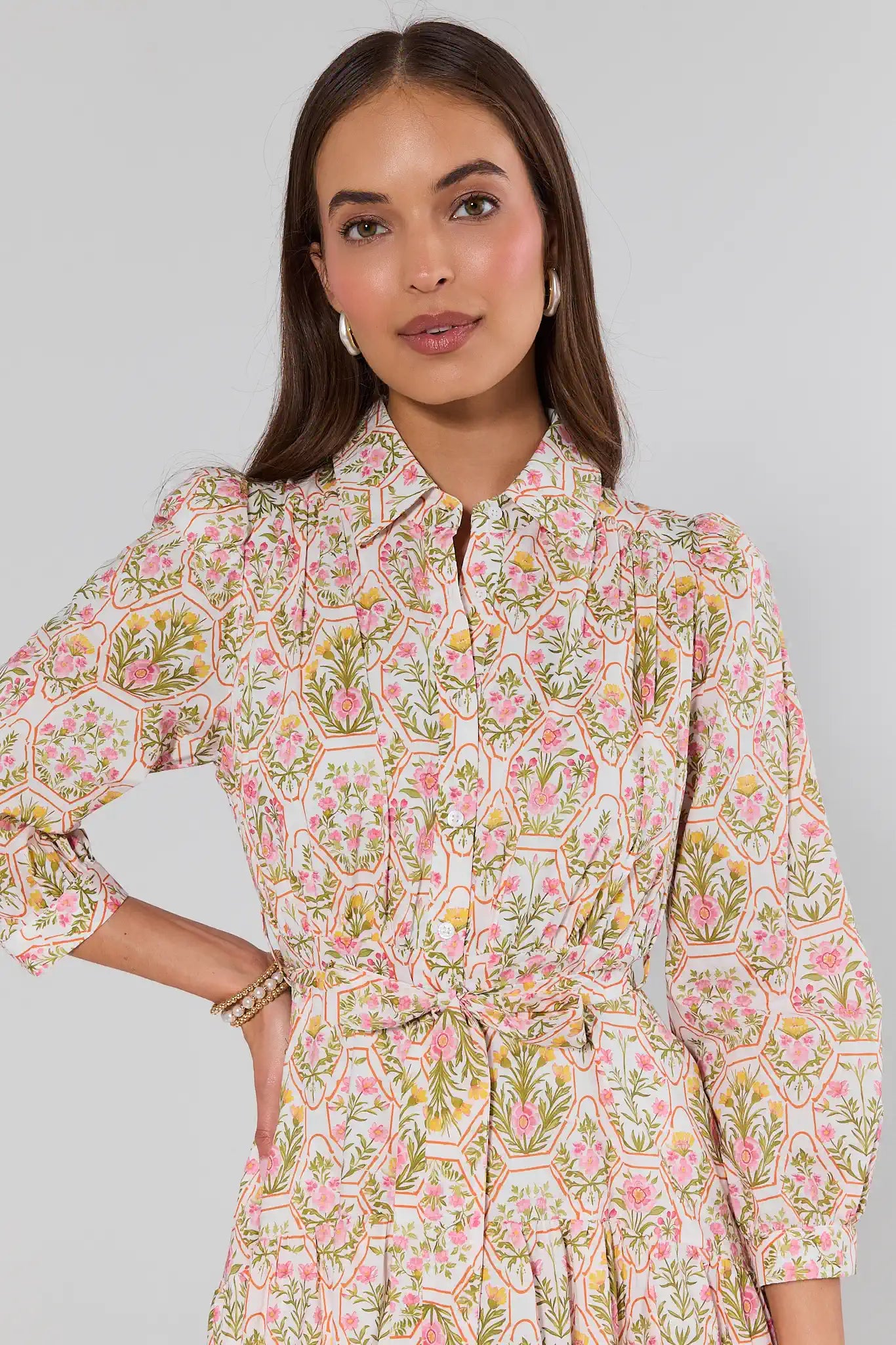 Woman wearing a floral dress against a plain background