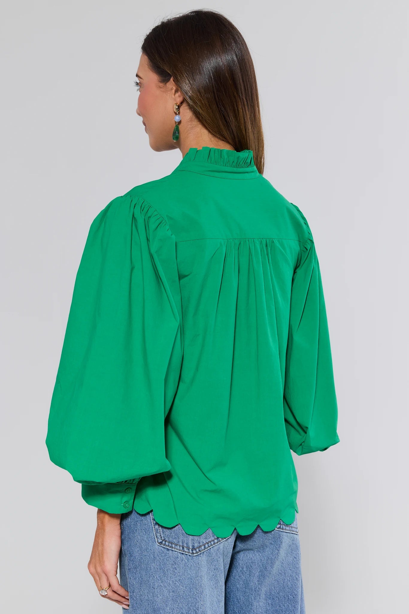 Green blouse worn by a person on a plain background