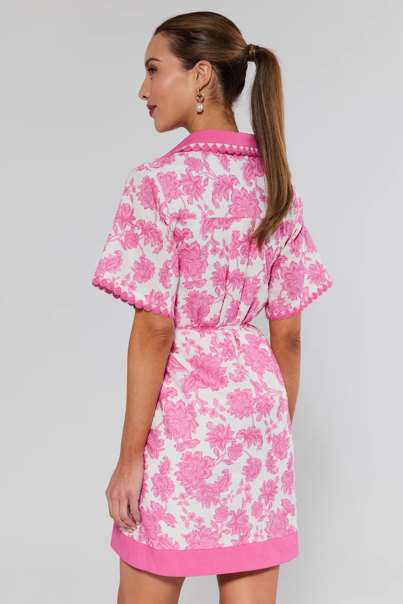 Woman wearing a pink floral dress against a white background