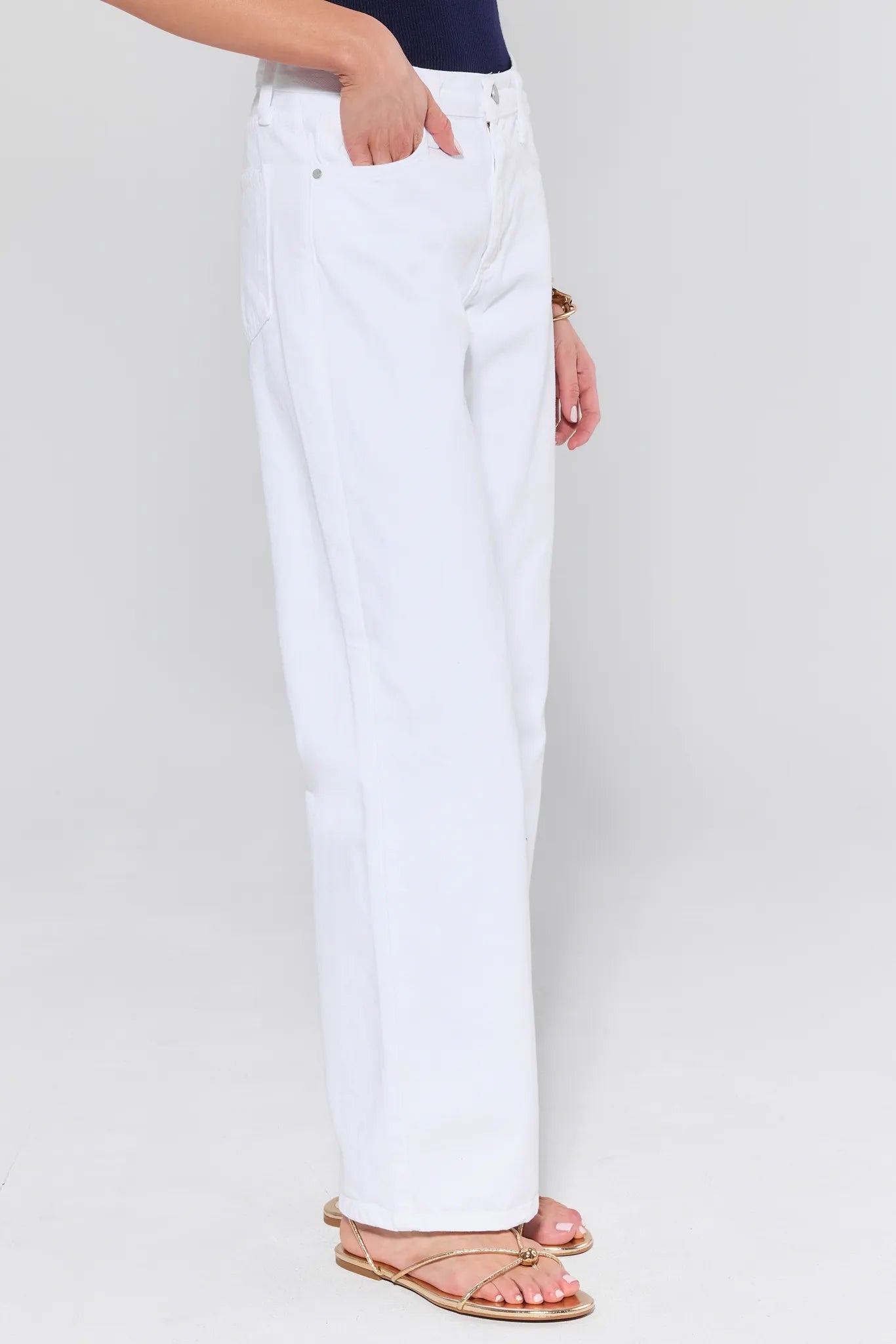 White pants worn by a person on a plain background