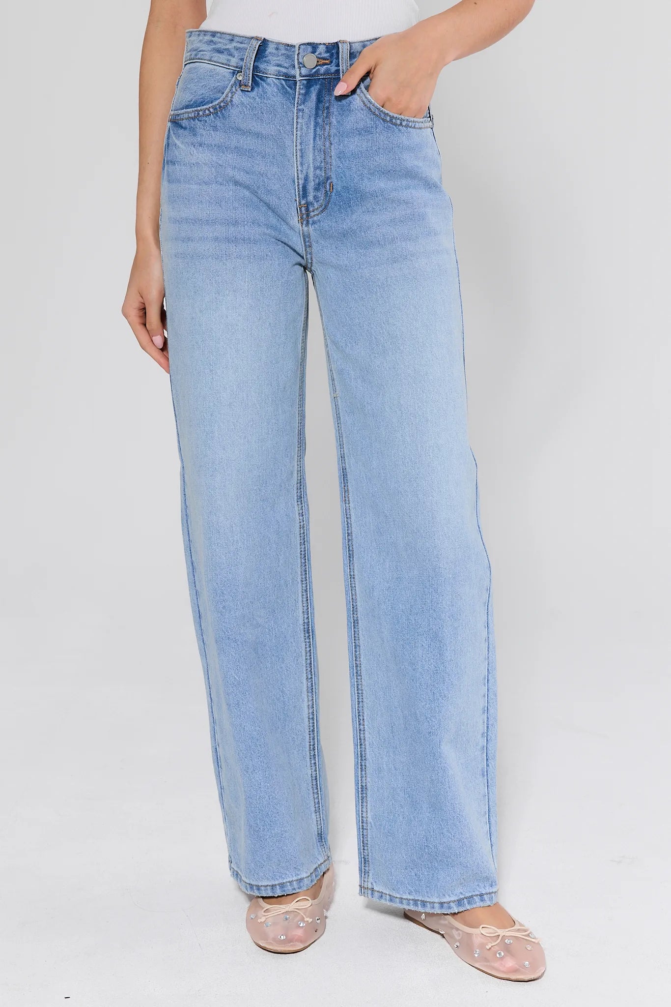 light wash jeans with mesh flats on white background