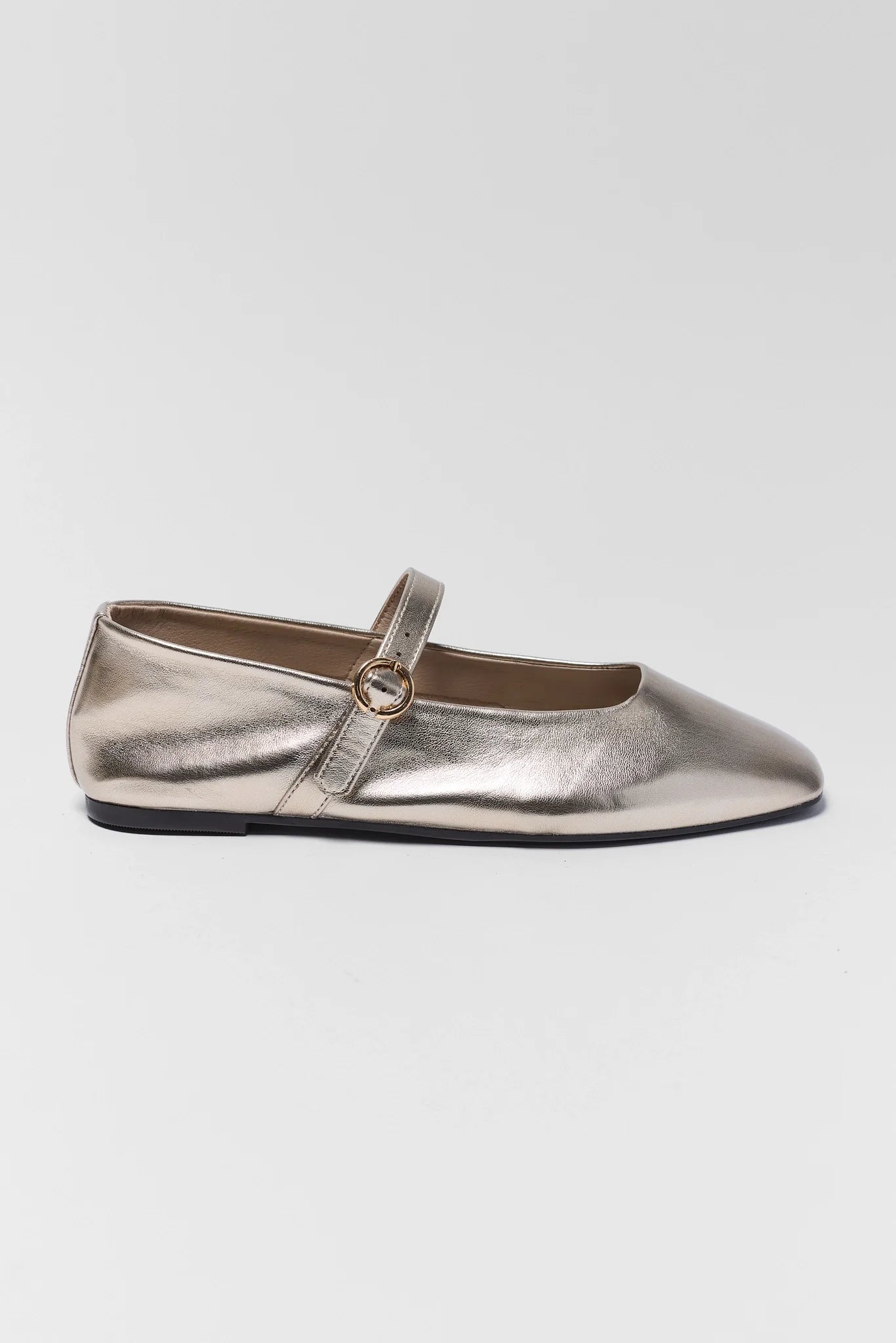 Silver metallic flat shoe with a strap on a white background