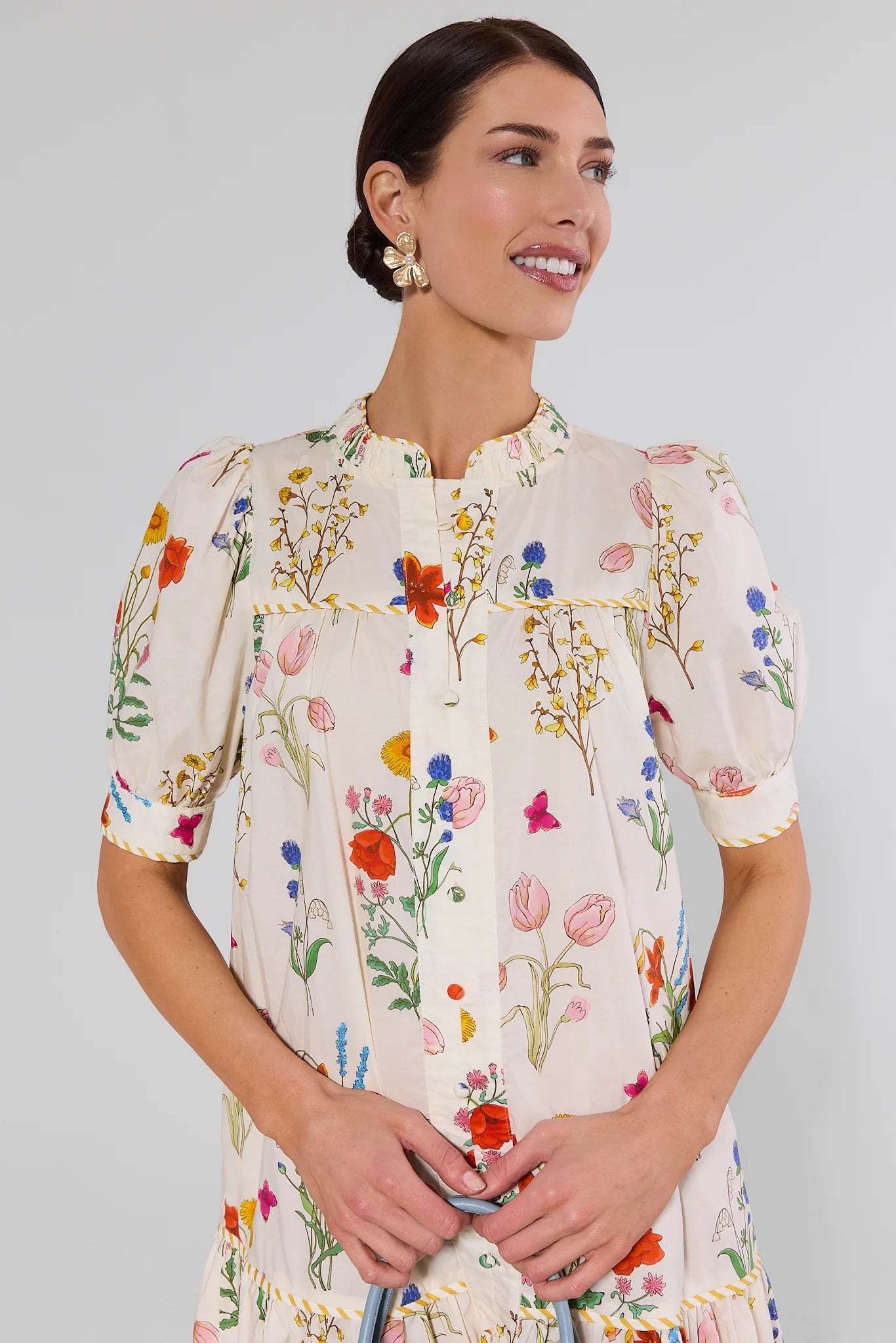 Woman wearing a white floral dress with a plain background