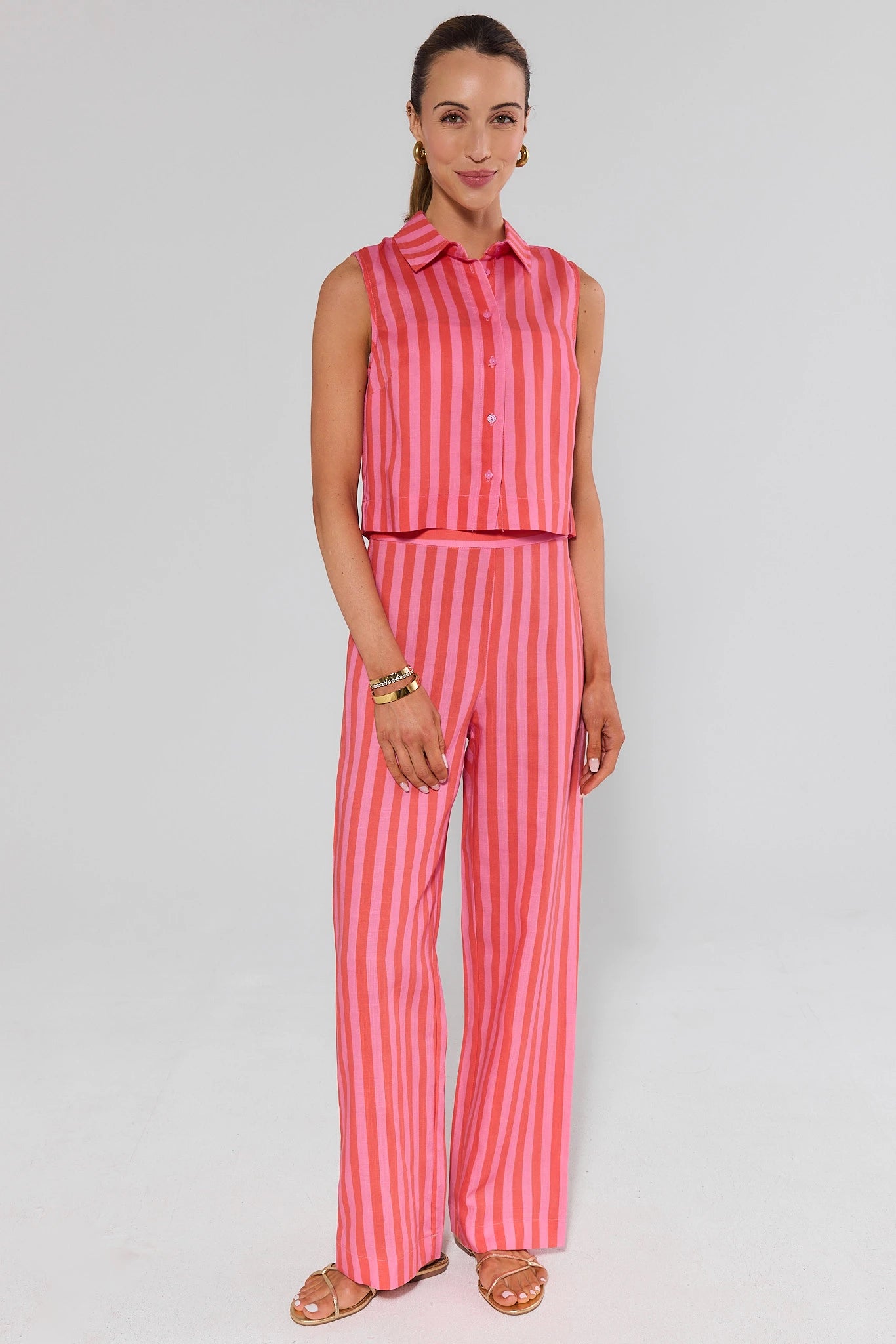 Woman wearing a pink and white striped outfit on a light gray background