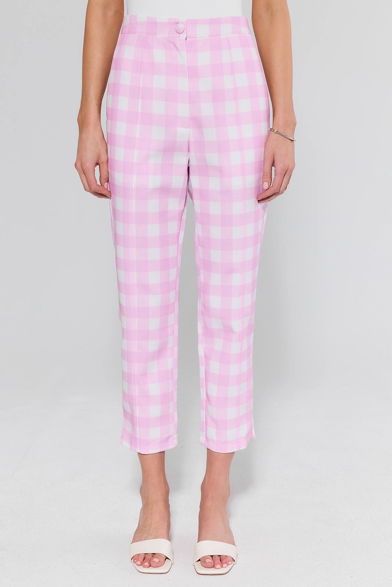 Person wearing pink checkered pants on a plain background