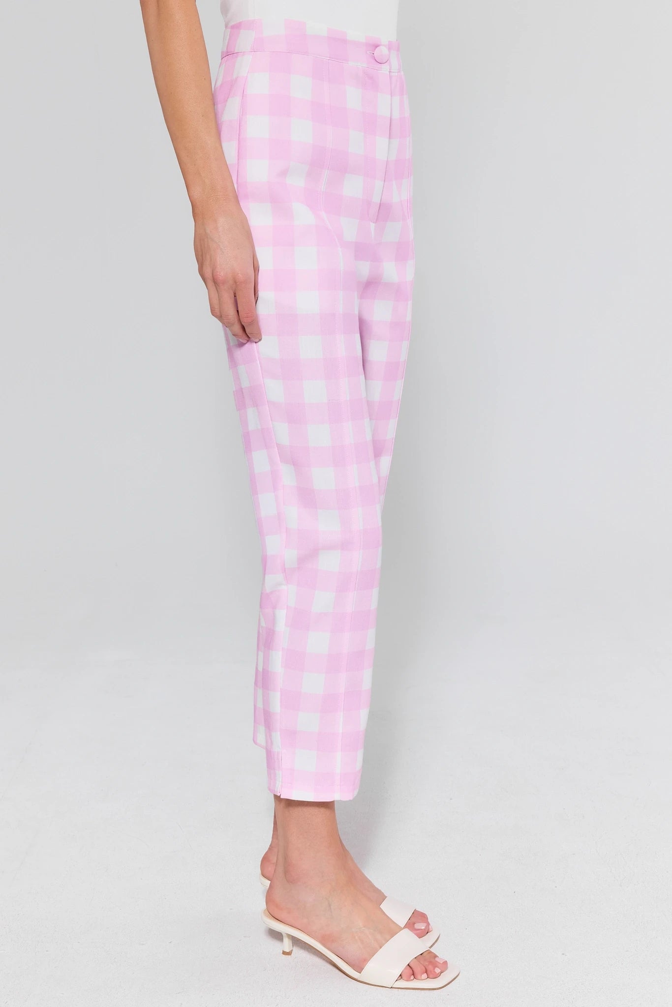 Pink checkered pants worn by a person on a light gray background
