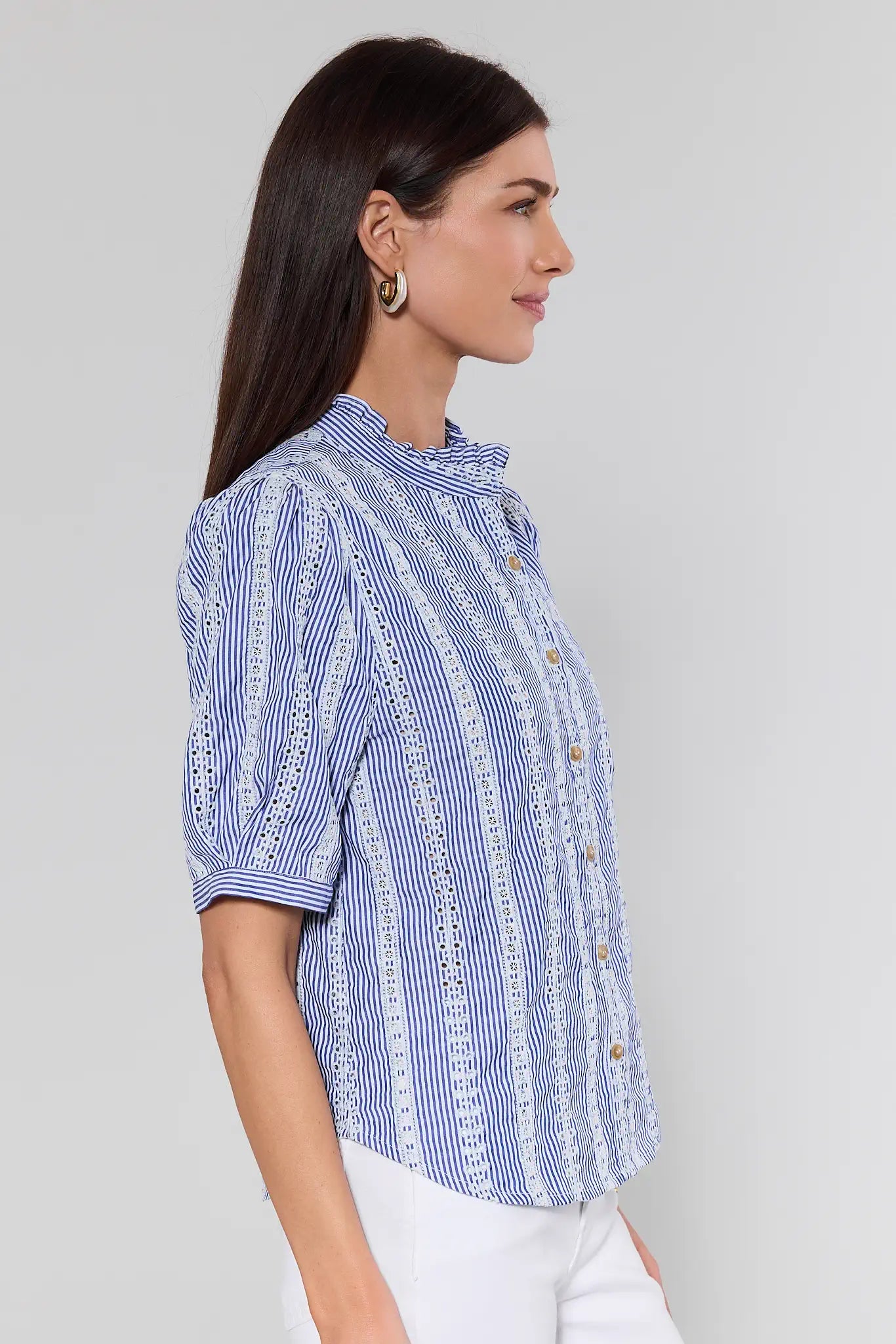 Woman wearing a blue and white striped shirt on a gray background