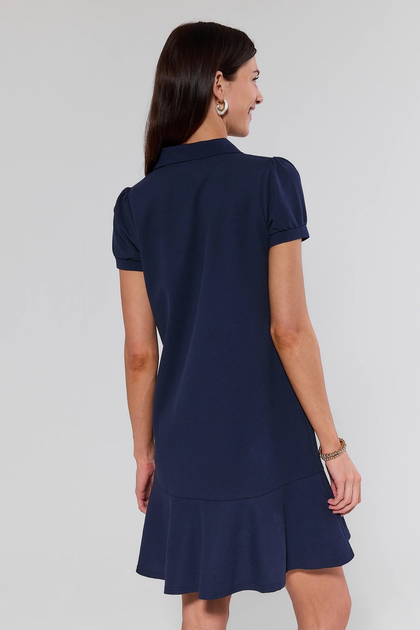 Woman wearing a navy blue dress with a white background