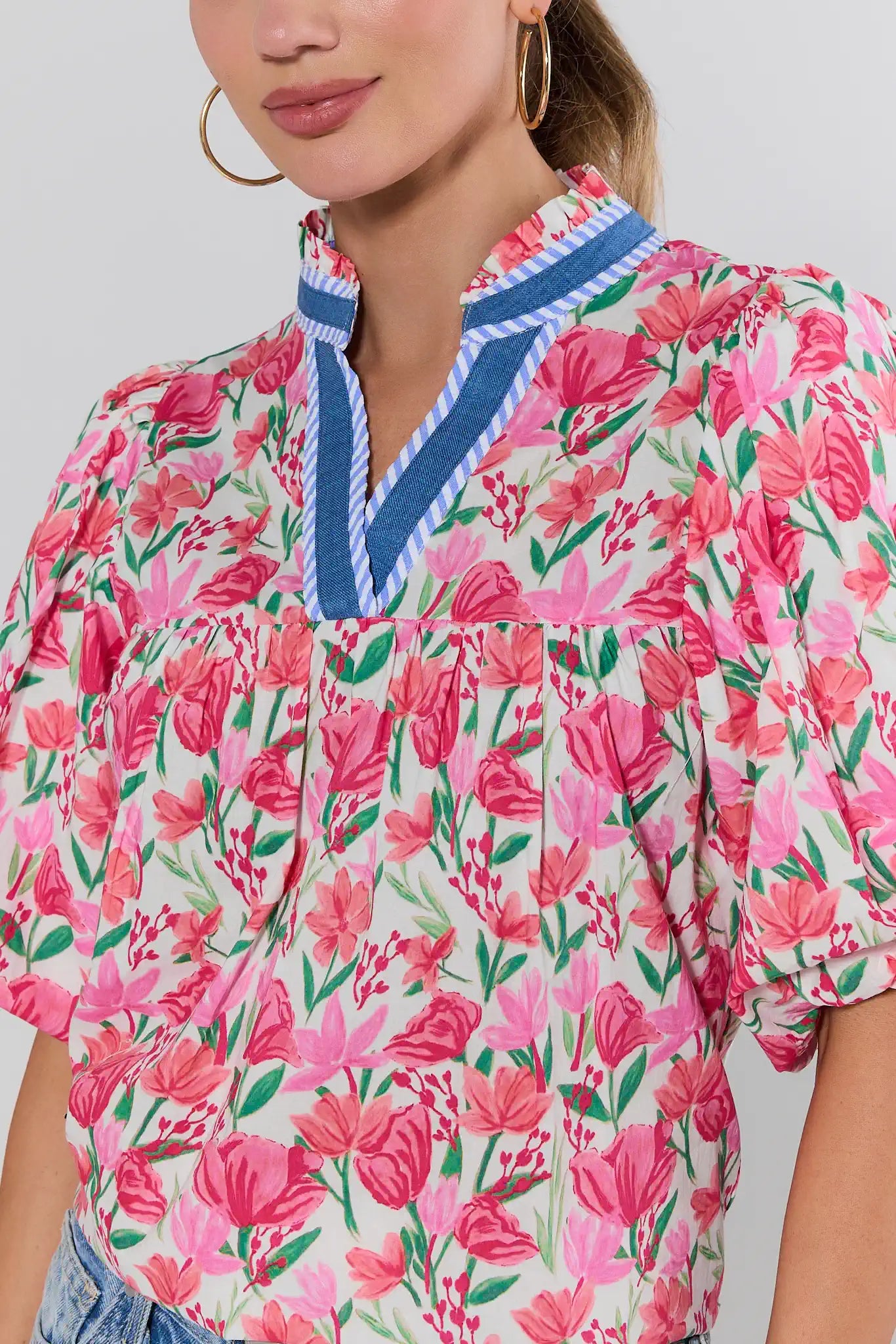 Woman wearing a floral blouse with pink flowers on a white background