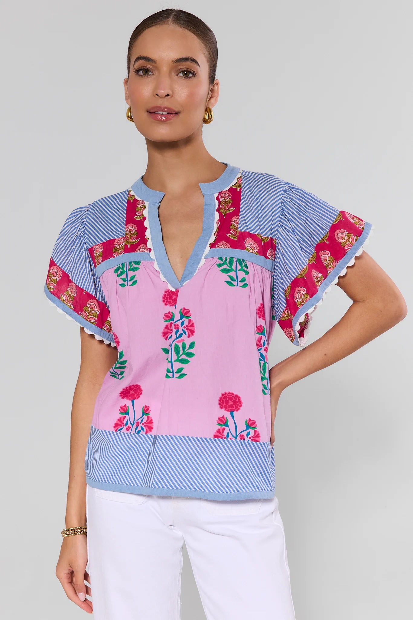 Woman wearing a colorful floral blouse with a plain background