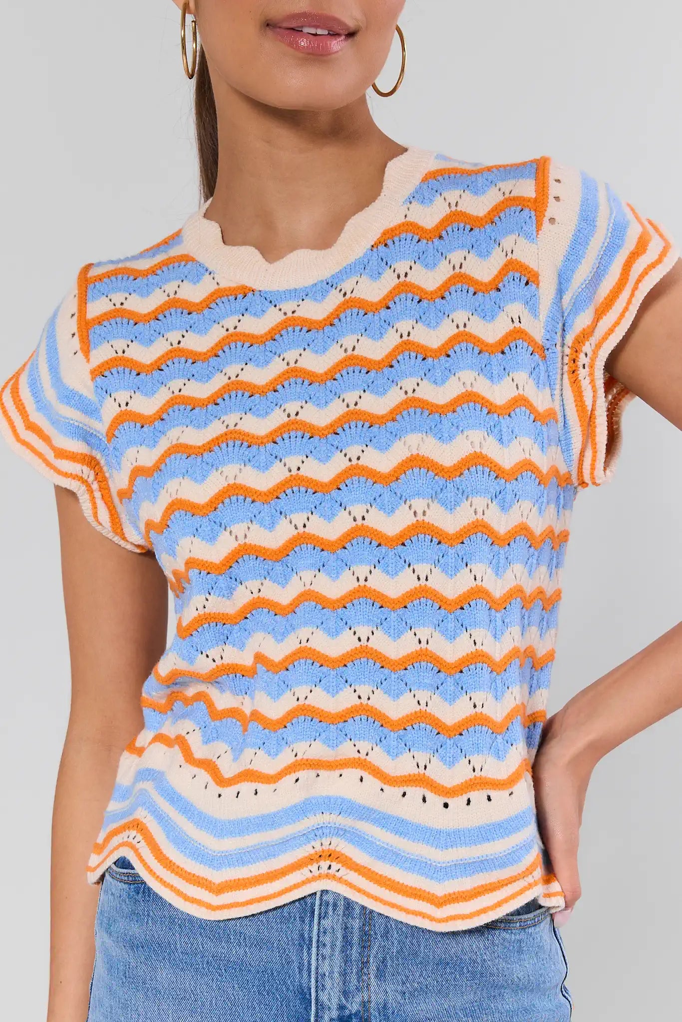 Person wearing a colorful striped shirt with a plain background