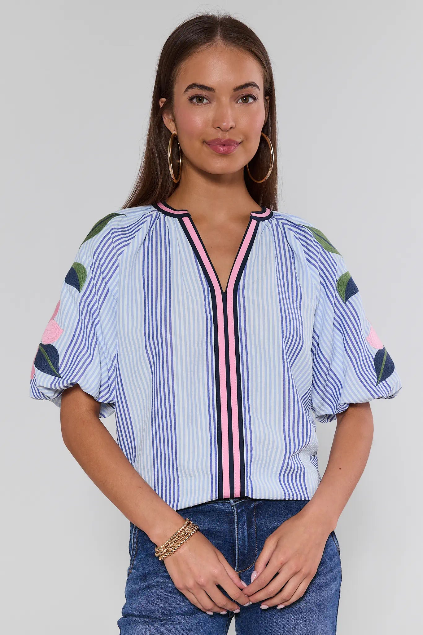 Woman wearing a colorful striped blouse with a plain background